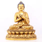 A serene gilt bronze statue of Gautama Buddha