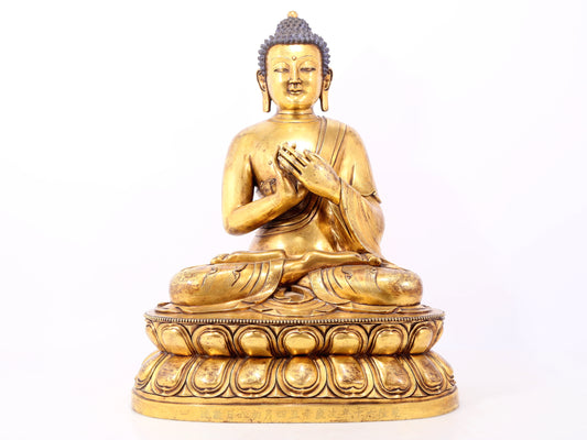 A serene gilt bronze statue of Gautama Buddha