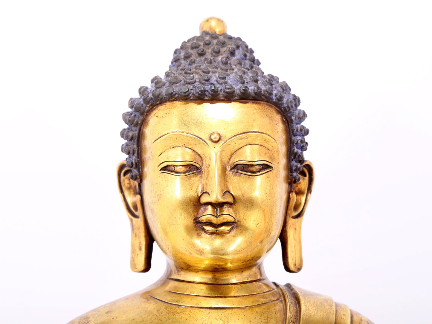 A serene gilt bronze statue of Gautama Buddha