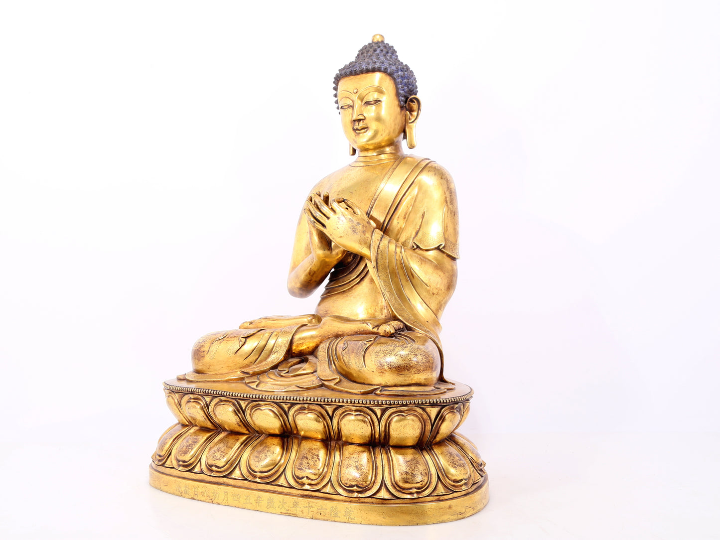 A serene gilt bronze statue of Gautama Buddha