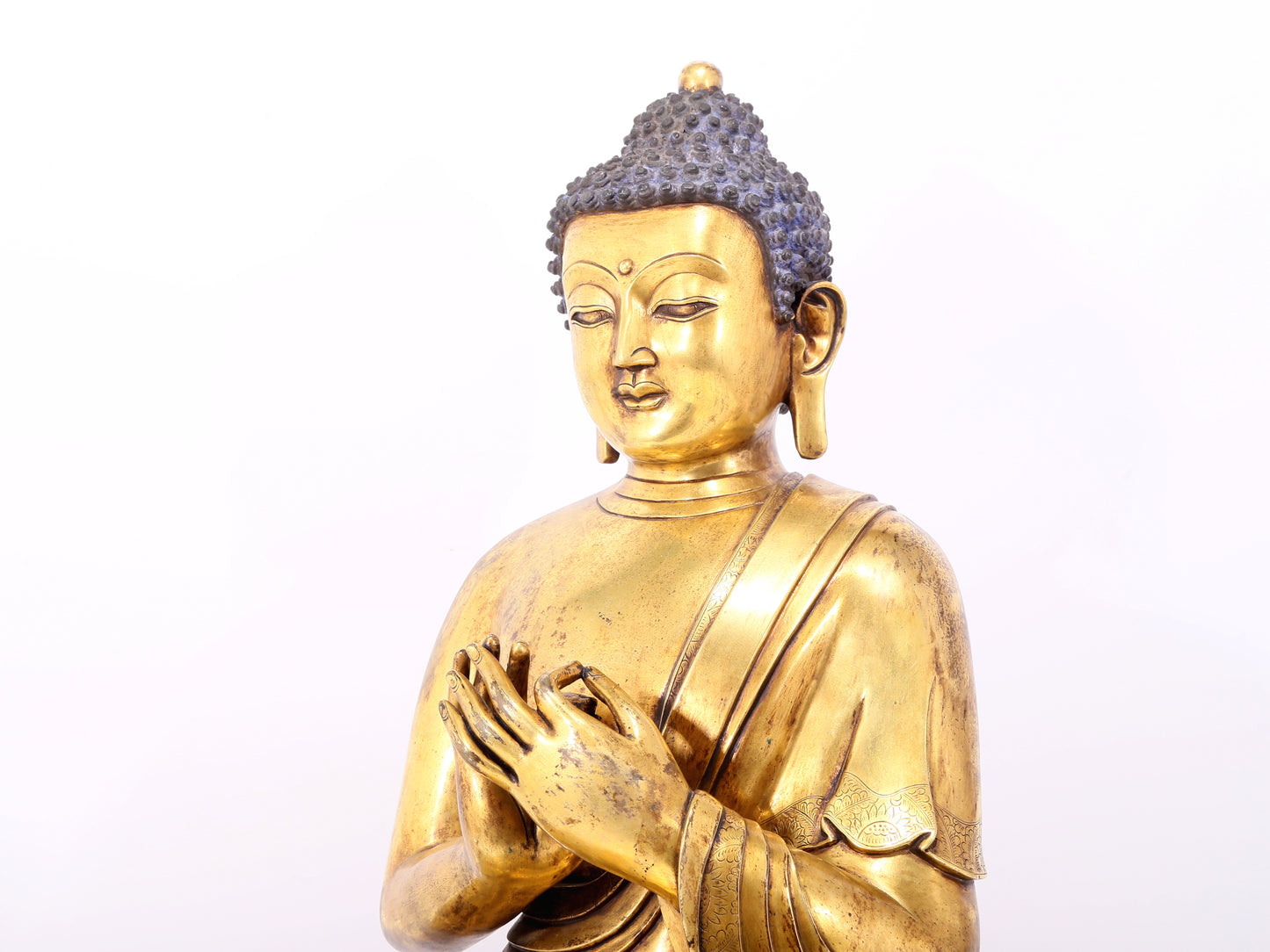 A serene gilt bronze statue of Gautama Buddha