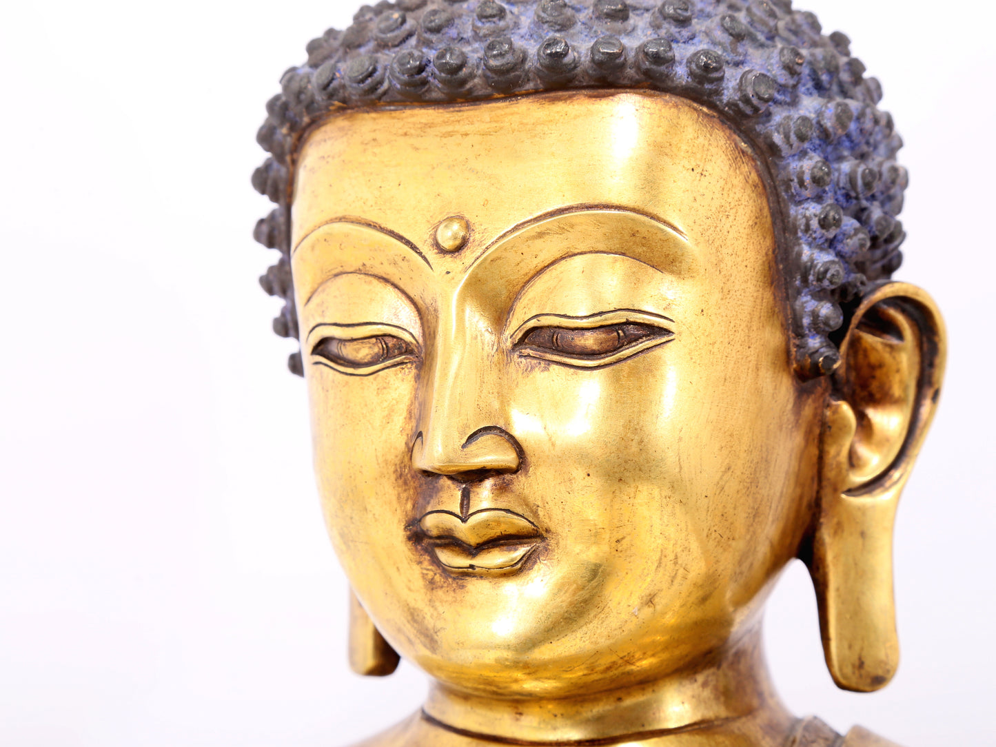 A serene gilt bronze statue of Gautama Buddha