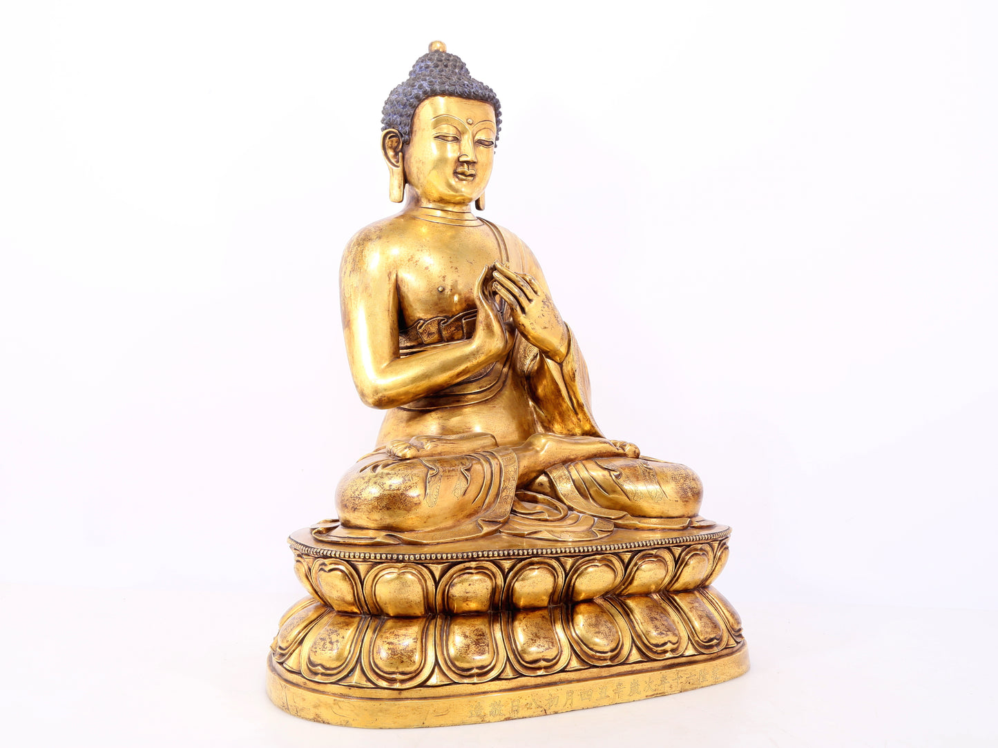 A serene gilt bronze statue of Gautama Buddha