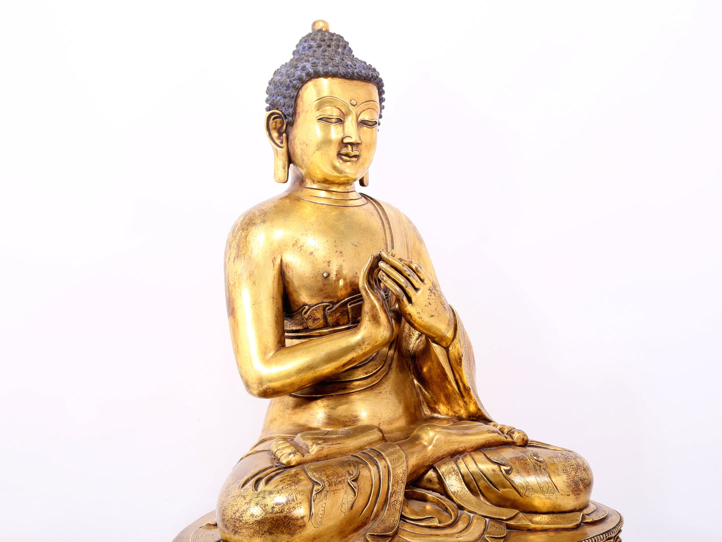 A serene gilt bronze statue of Gautama Buddha