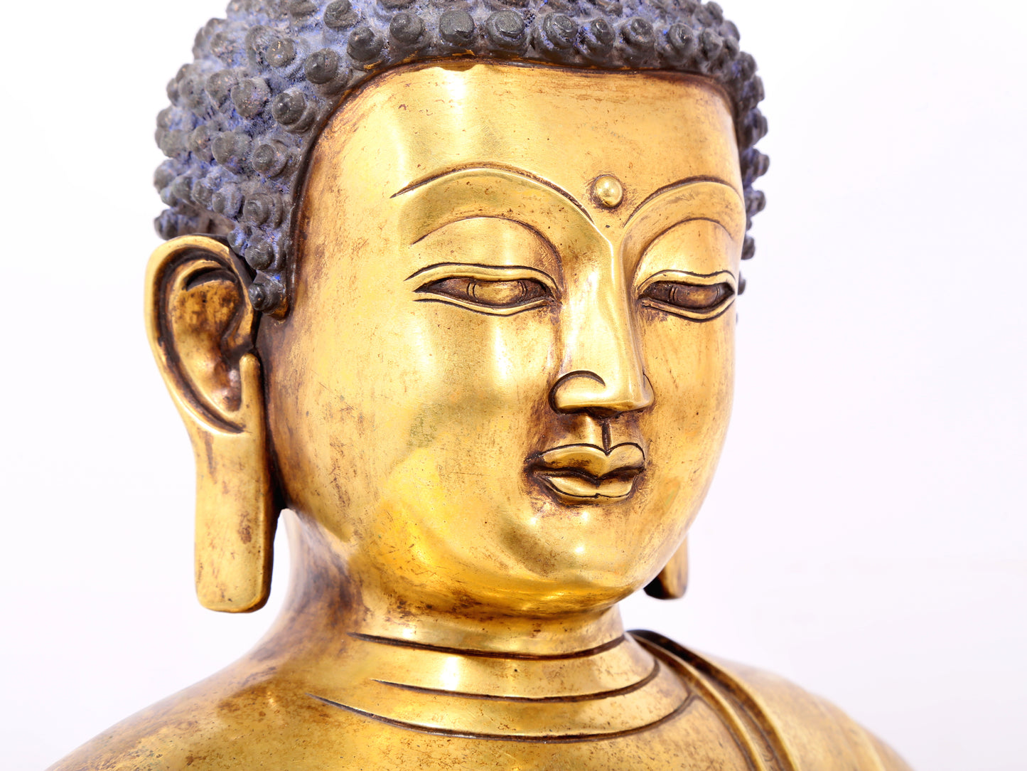 A serene gilt bronze statue of Gautama Buddha