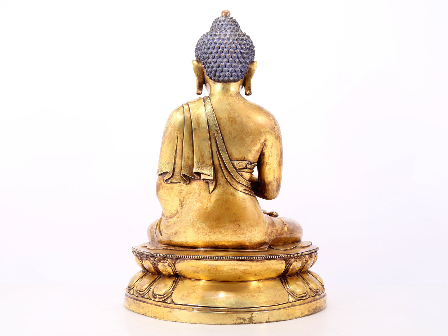 A serene gilt bronze statue of Gautama Buddha