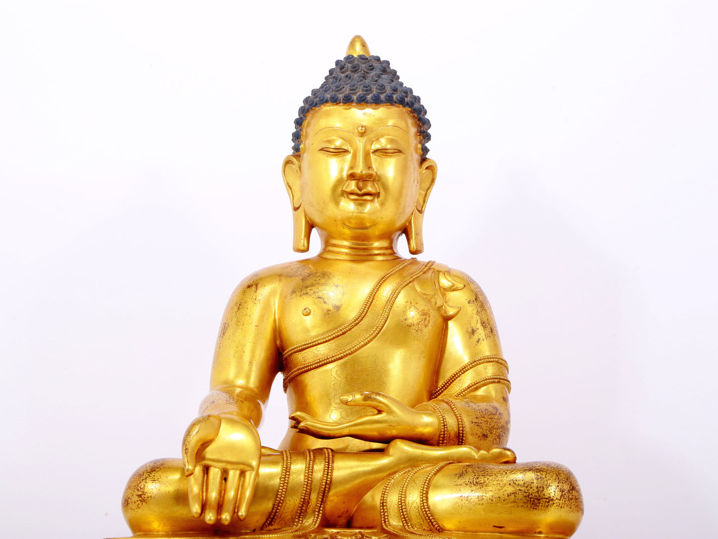 A serene gilt bronze statue of Gautama Buddha