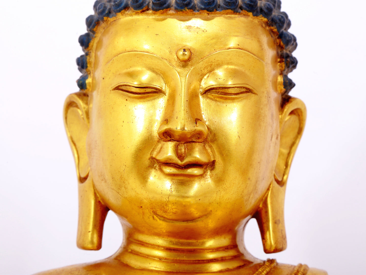 A serene gilt bronze statue of Gautama Buddha