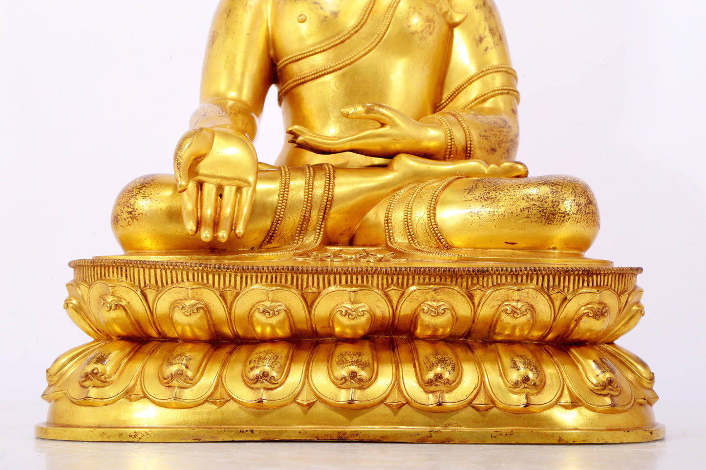 A serene gilt bronze statue of Gautama Buddha