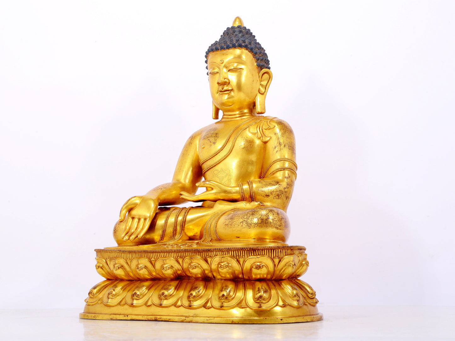 A serene gilt bronze statue of Gautama Buddha