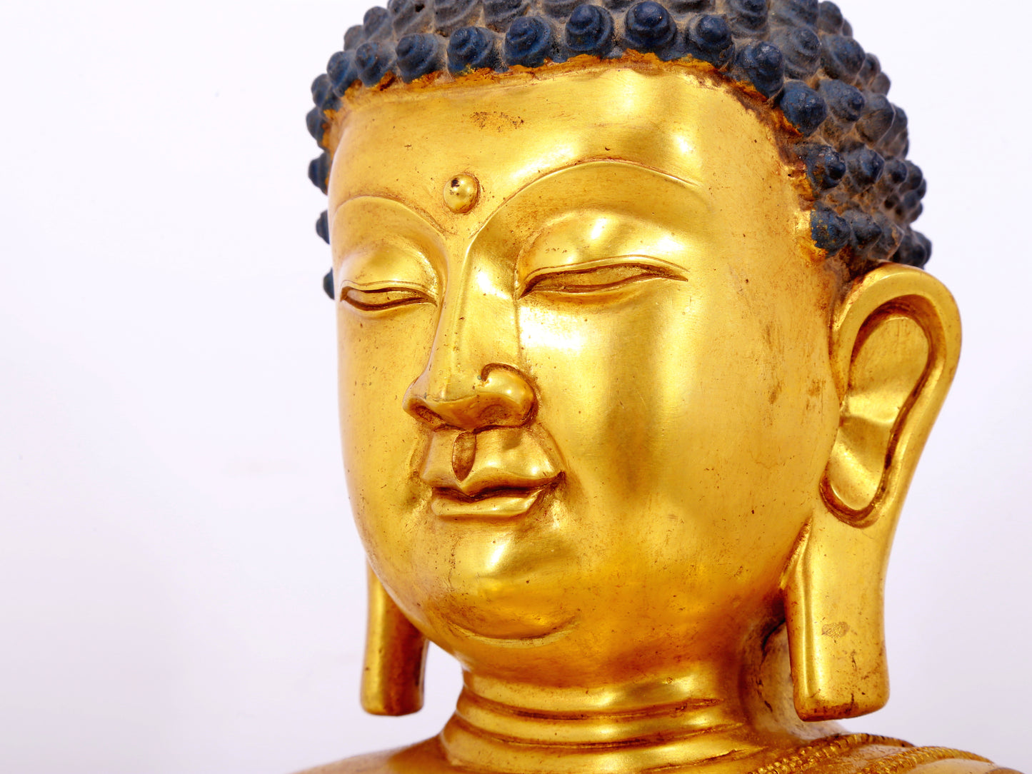 A serene gilt bronze statue of Gautama Buddha