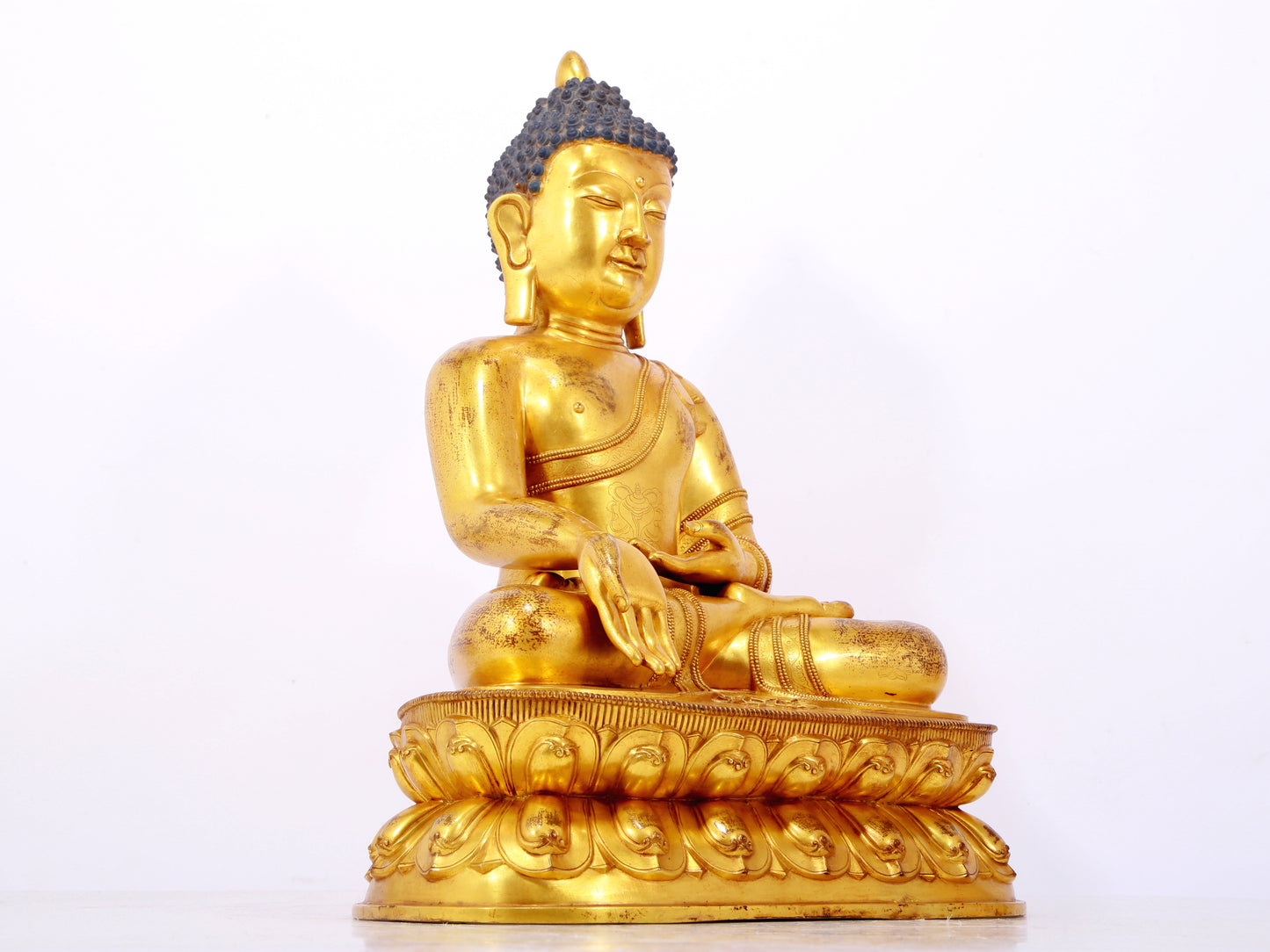 A serene gilt bronze statue of Gautama Buddha