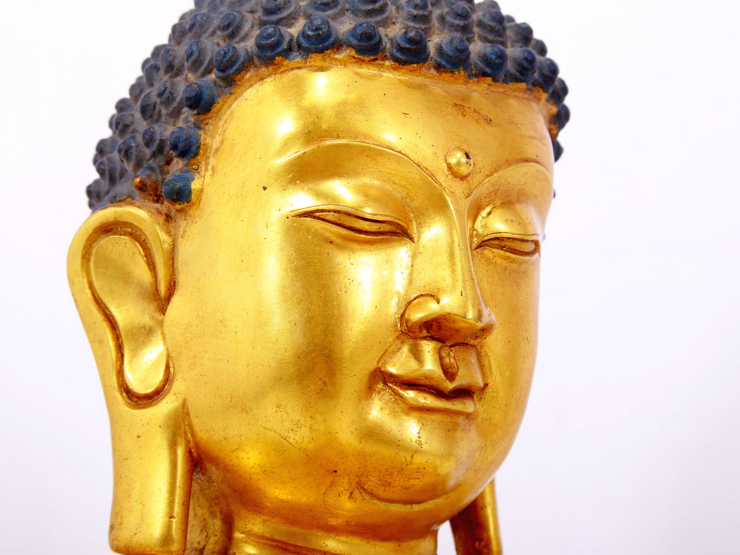 A serene gilt bronze statue of Gautama Buddha