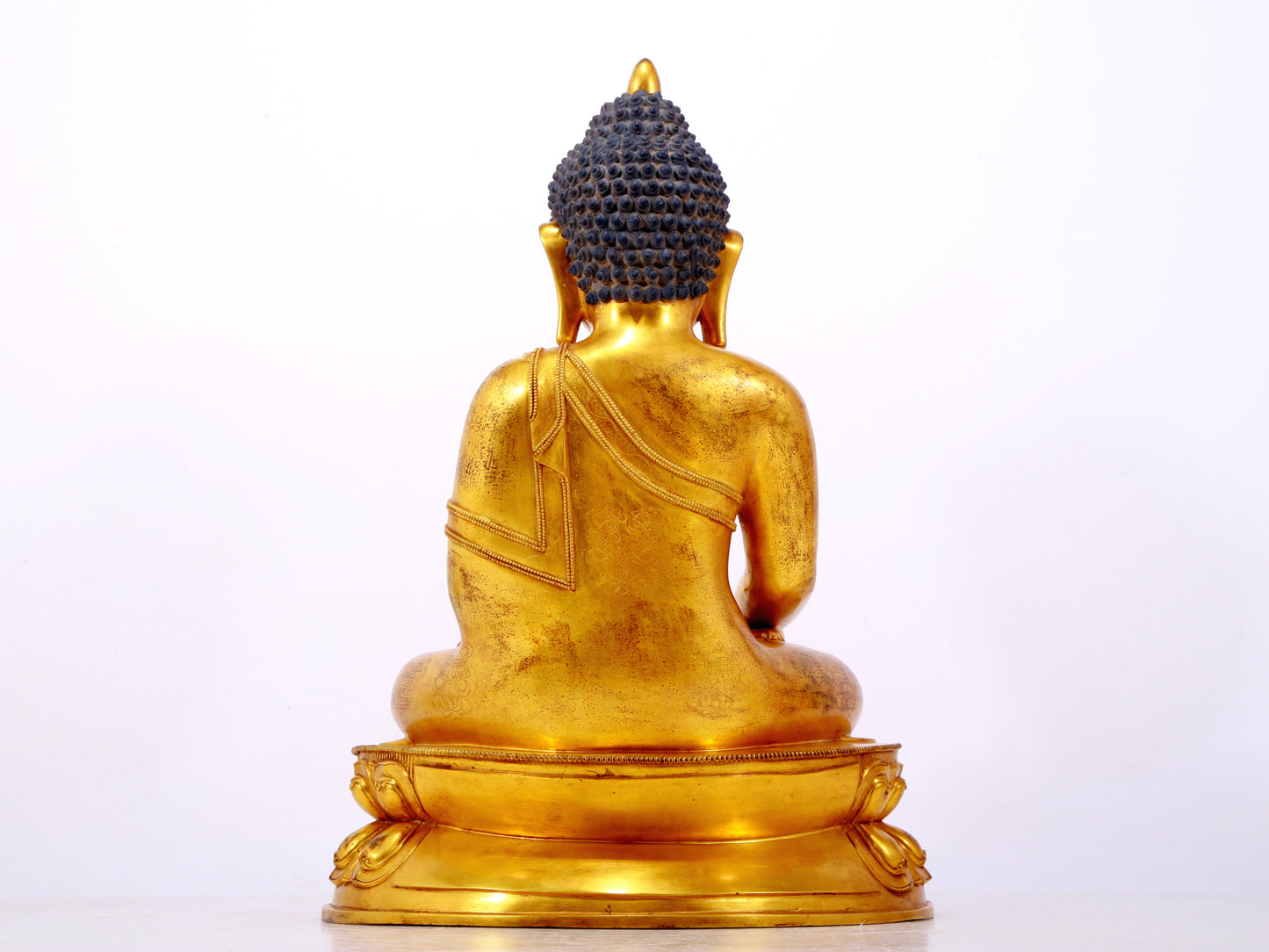 A serene gilt bronze statue of Gautama Buddha