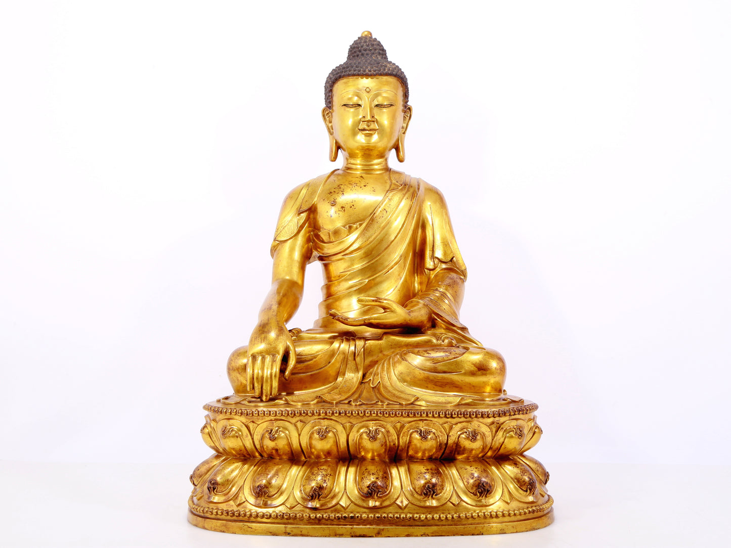 A serene gilt bronze statue of Gautama Buddha