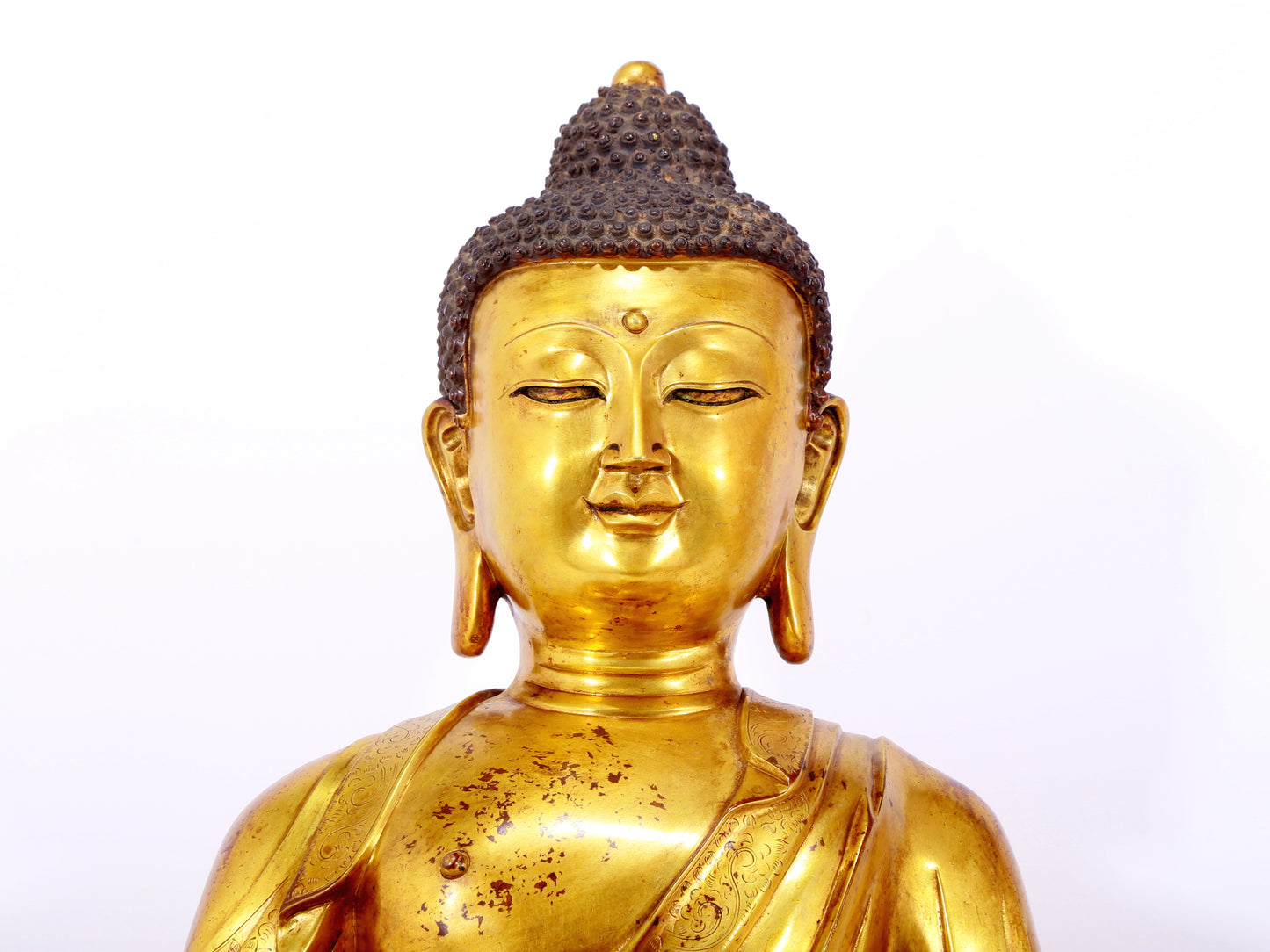 A serene gilt bronze statue of Gautama Buddha