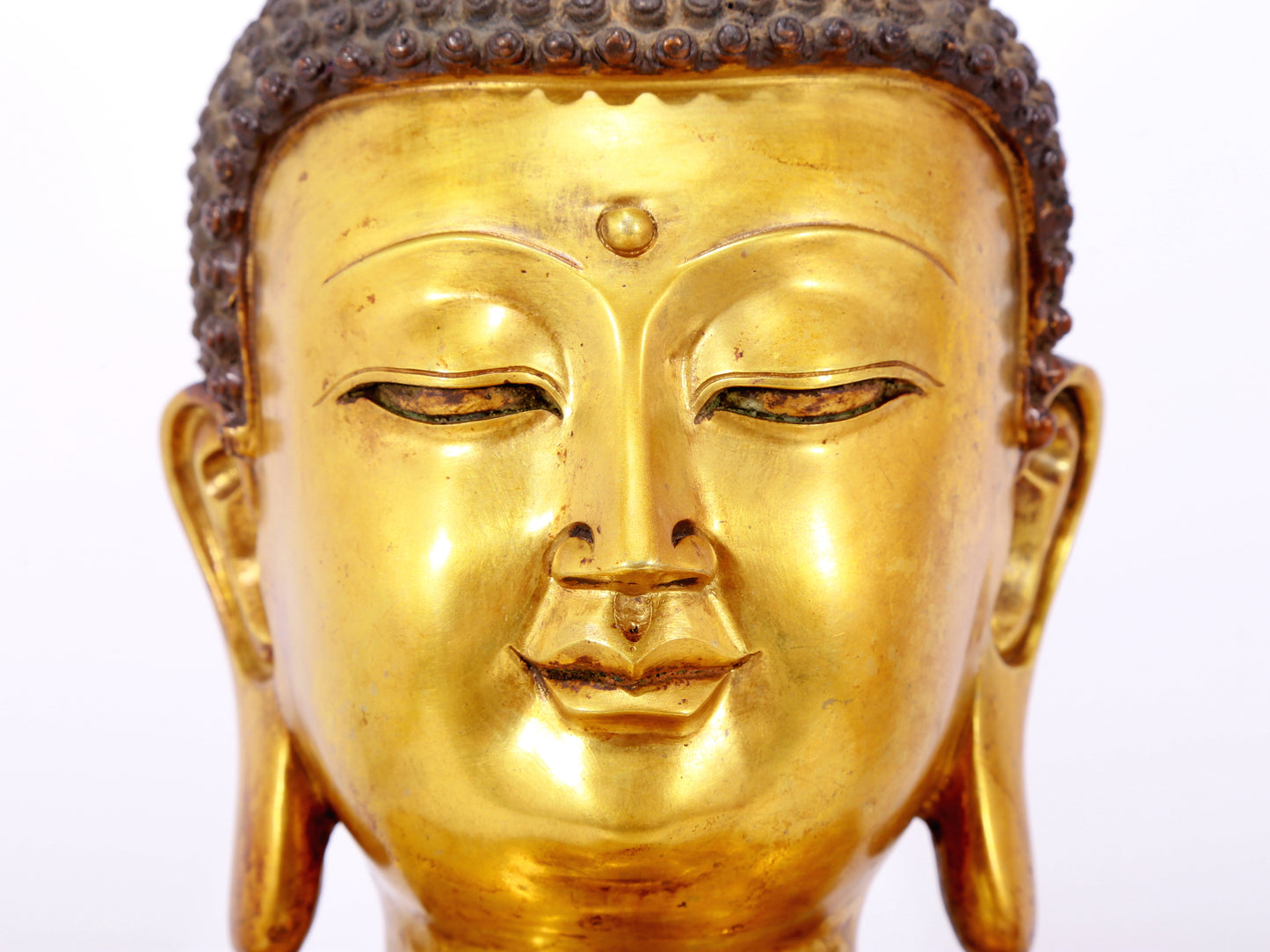 A serene gilt bronze statue of Gautama Buddha