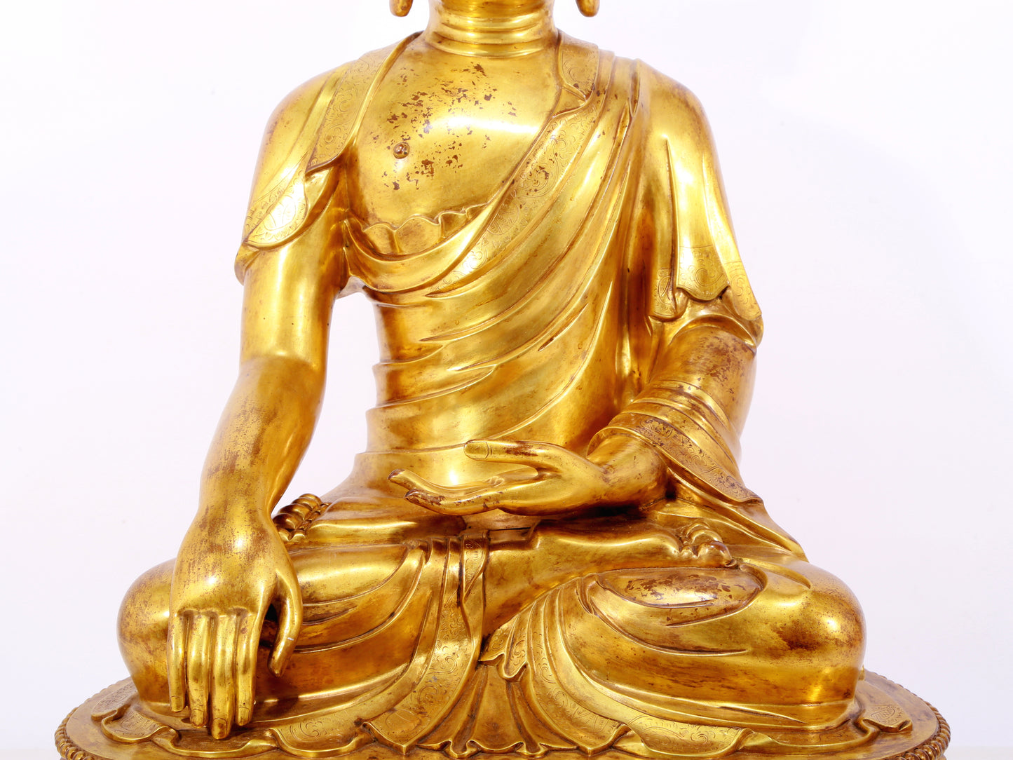 A serene gilt bronze statue of Gautama Buddha