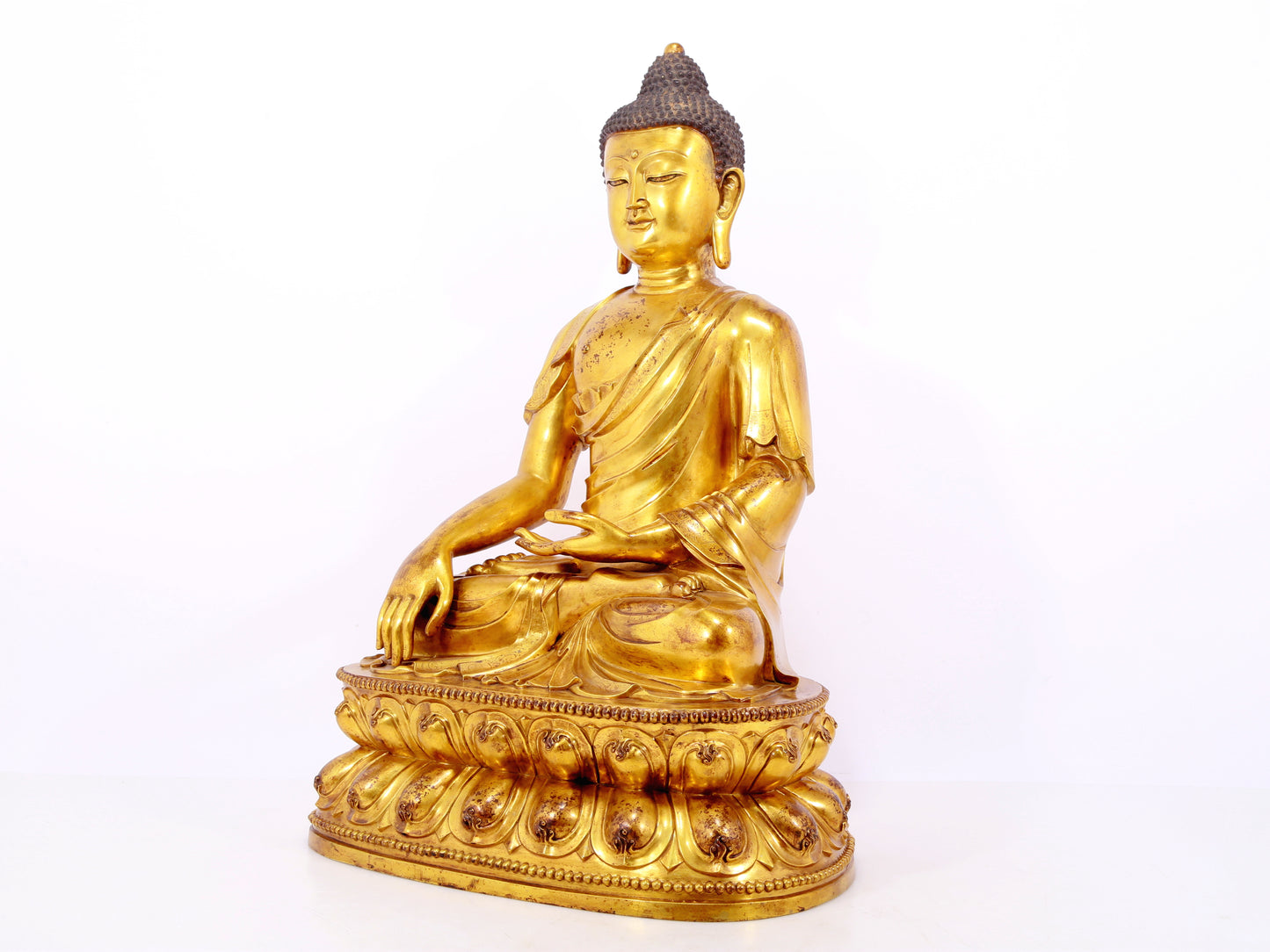 A serene gilt bronze statue of Gautama Buddha