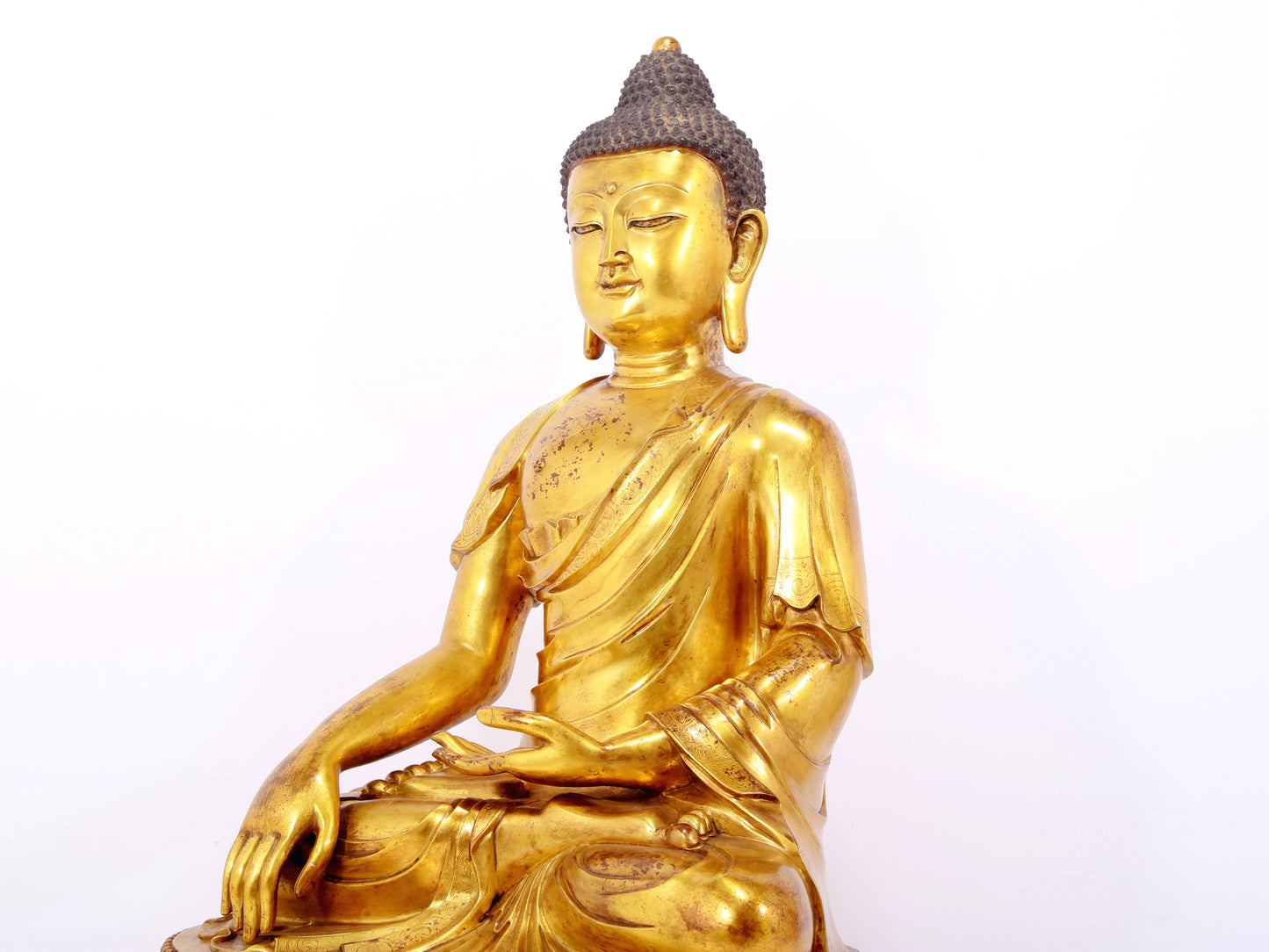 A serene gilt bronze statue of Gautama Buddha