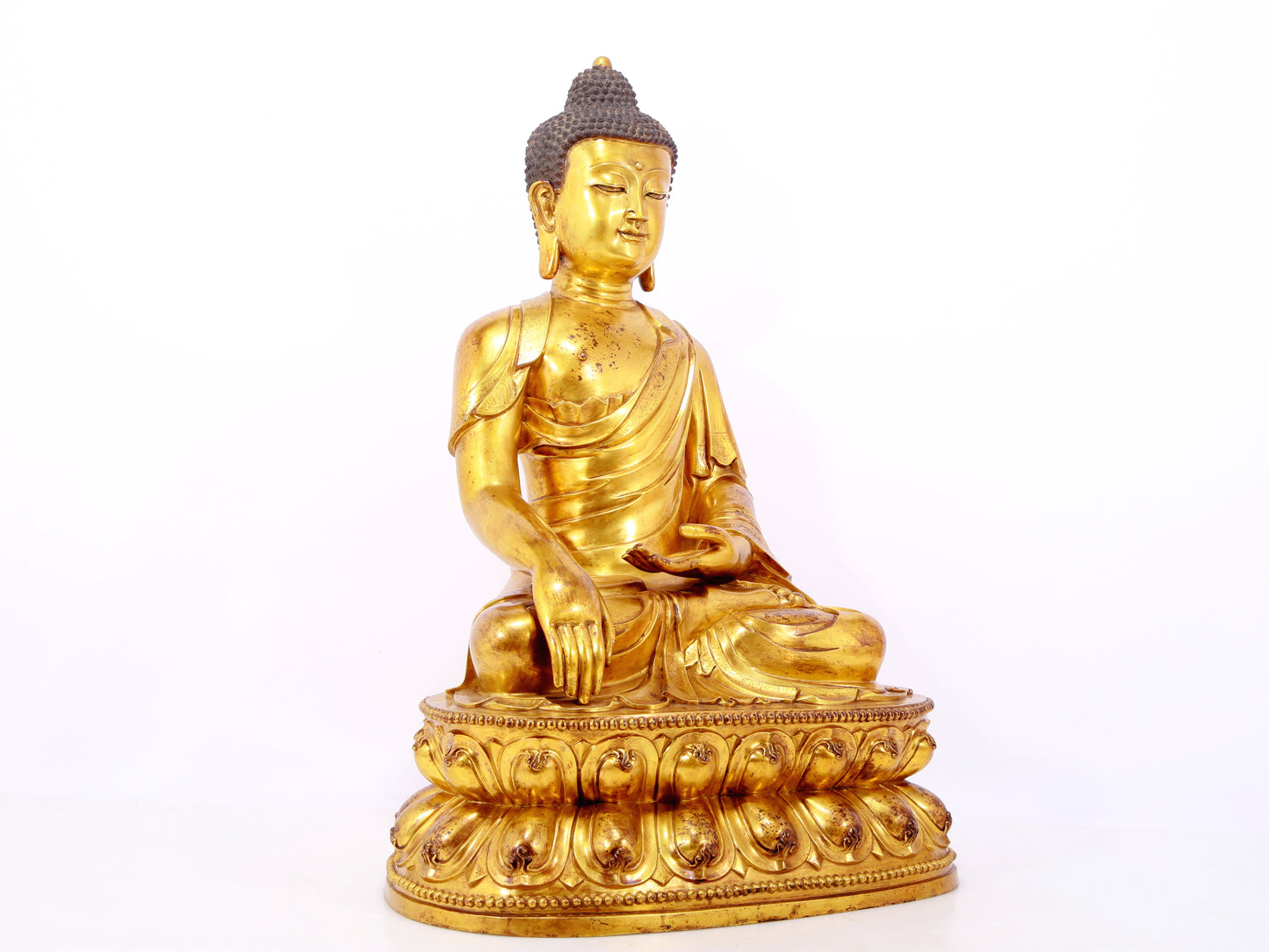 A serene gilt bronze statue of Gautama Buddha