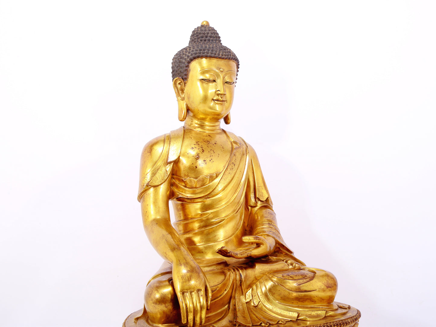 A serene gilt bronze statue of Gautama Buddha