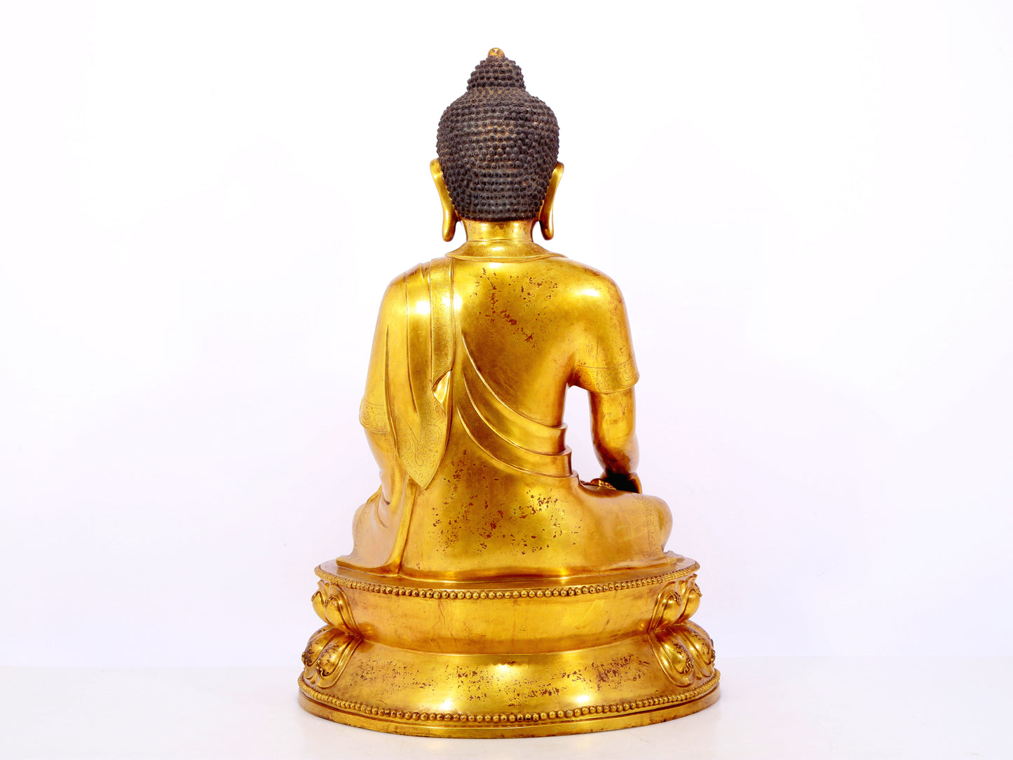 A serene gilt bronze statue of Gautama Buddha