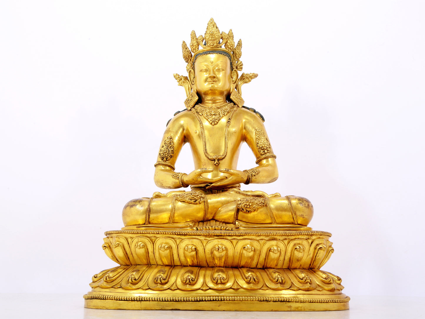 A serene gilt bronze statue of Amitayus Buddha