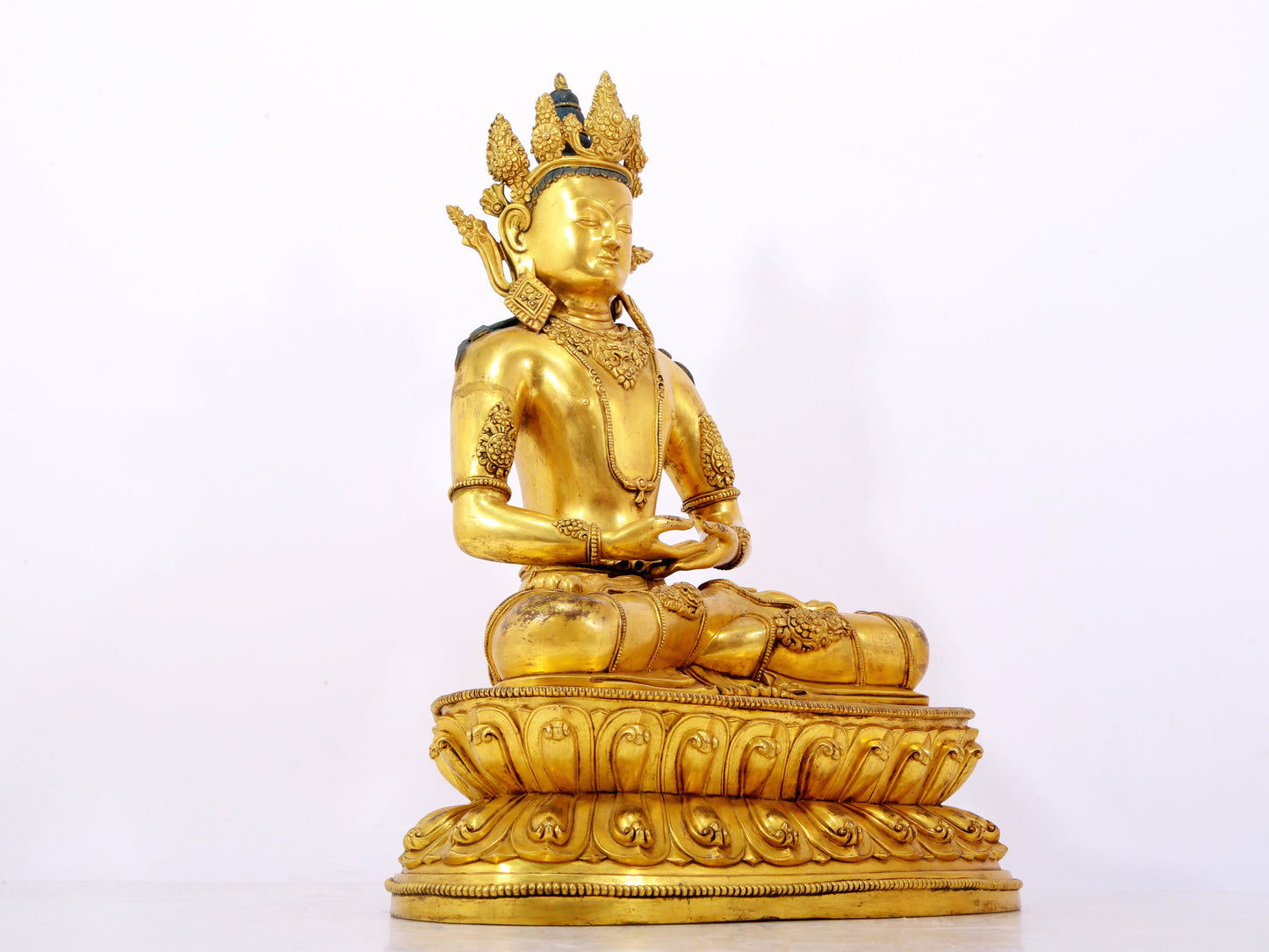 A serene gilt bronze statue of Amitayus Buddha