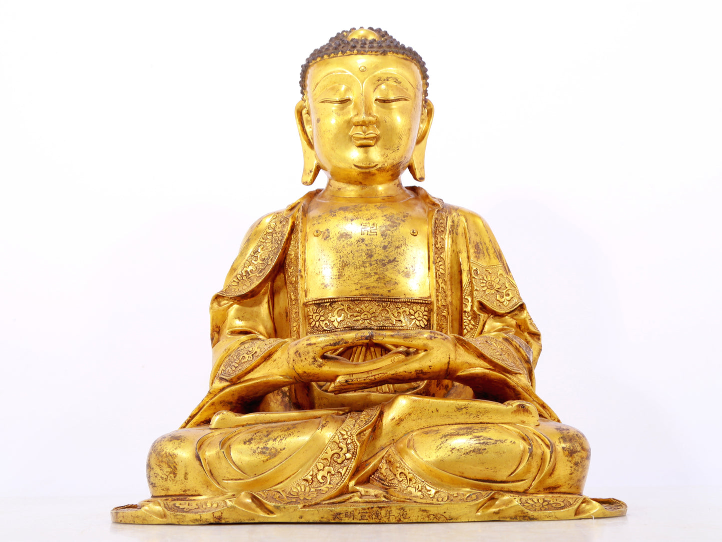 A serene gilt bronze statue of Gautama Buddha