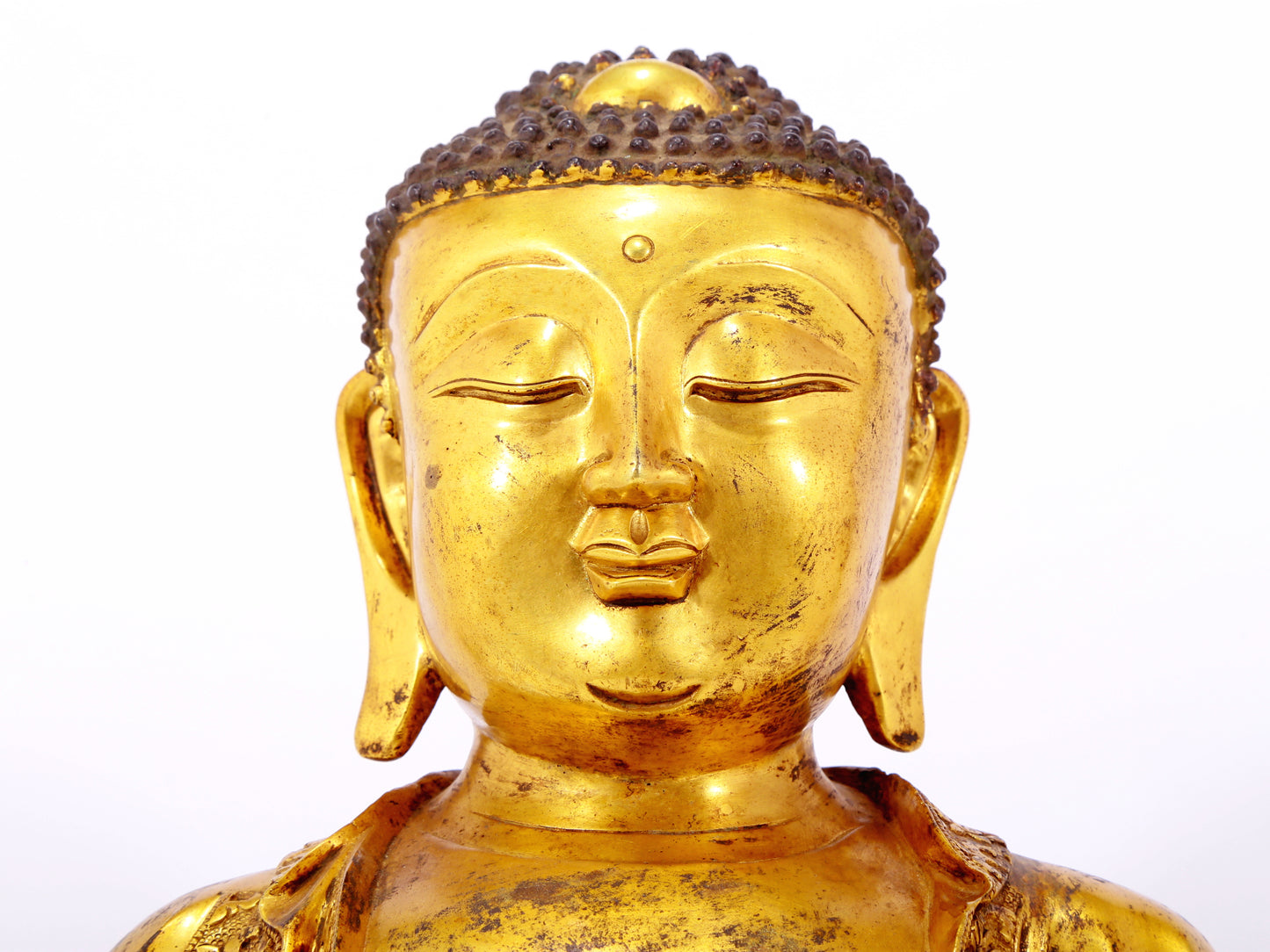 A serene gilt bronze statue of Gautama Buddha