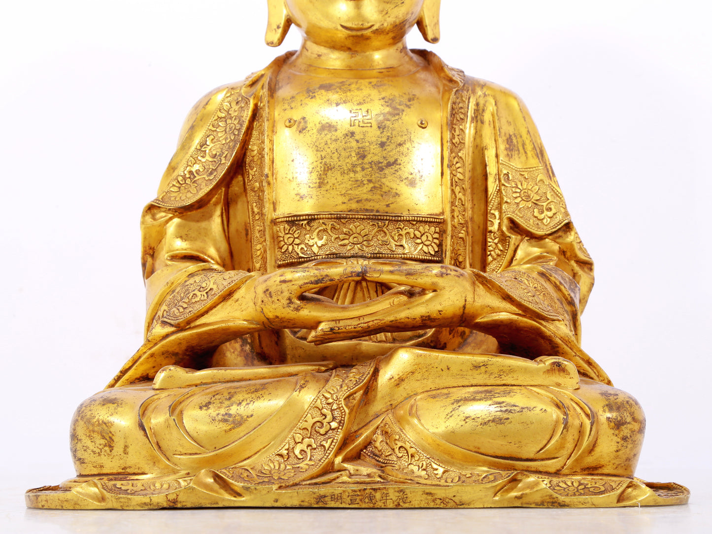 A serene gilt bronze statue of Gautama Buddha