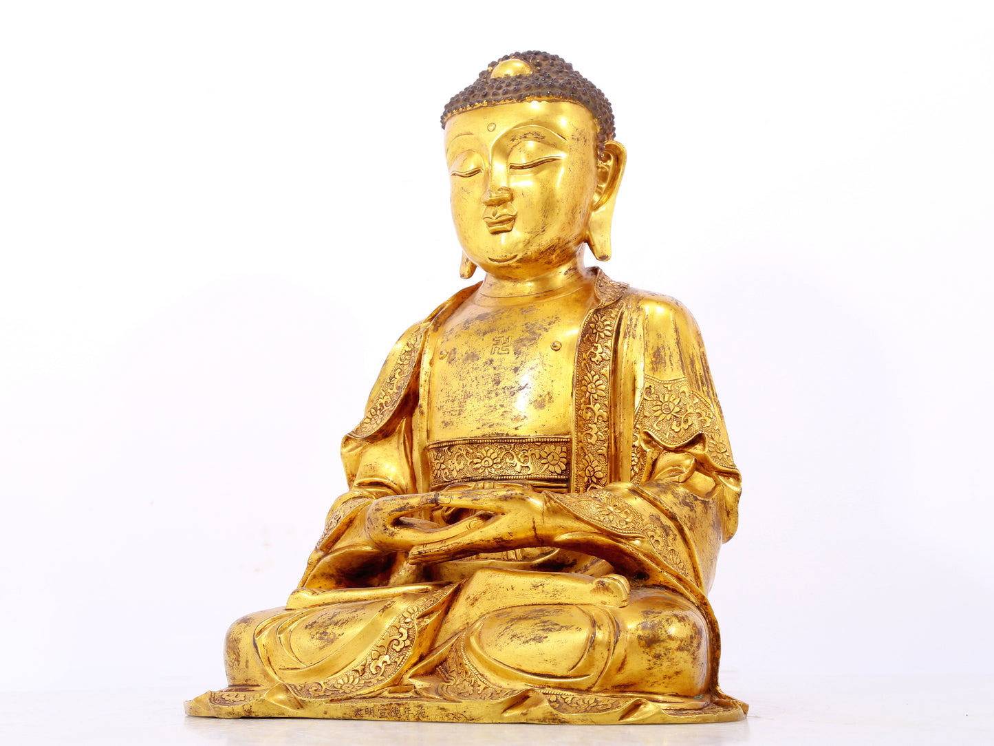 A serene gilt bronze statue of Gautama Buddha