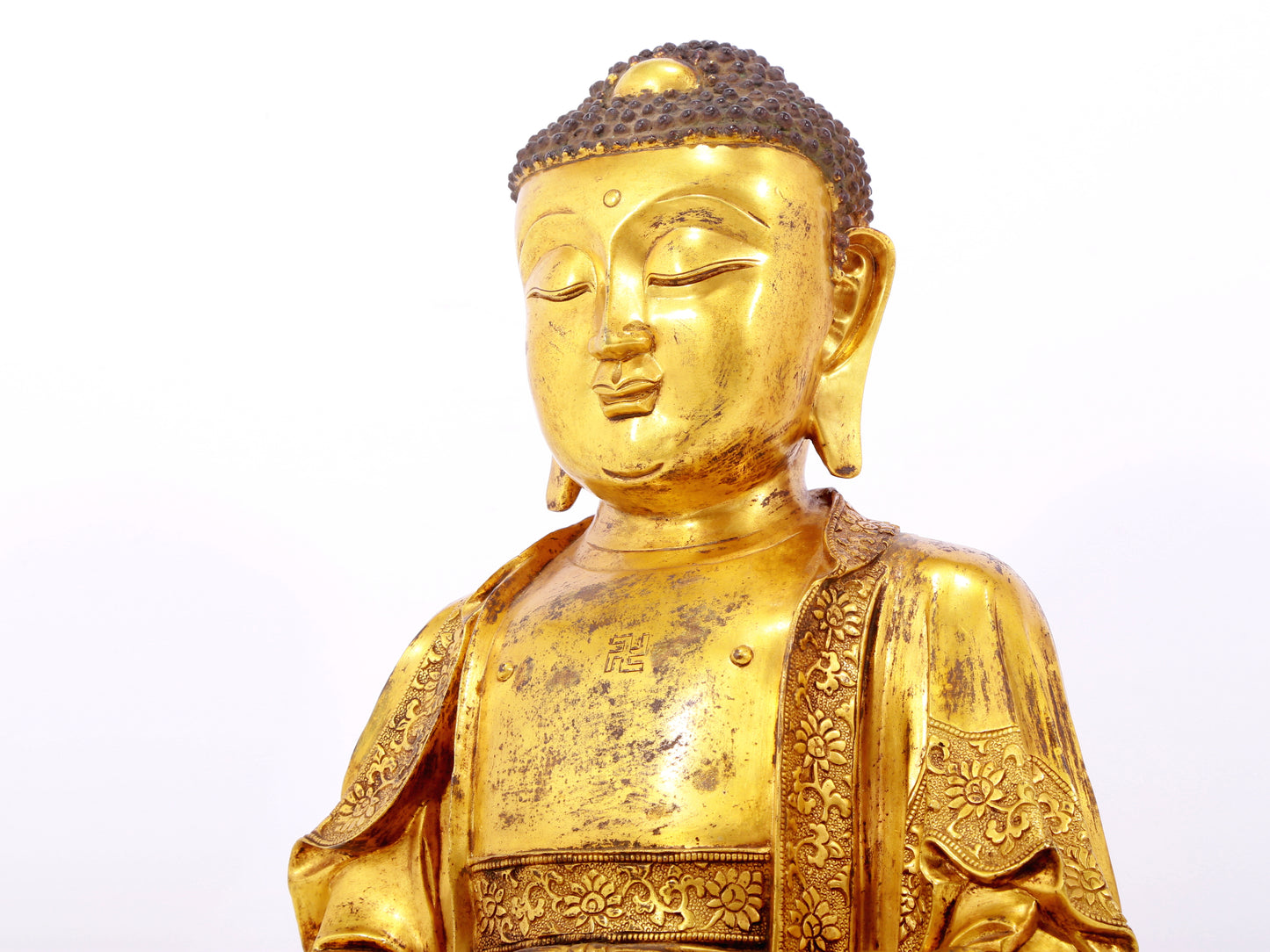 A serene gilt bronze statue of Gautama Buddha