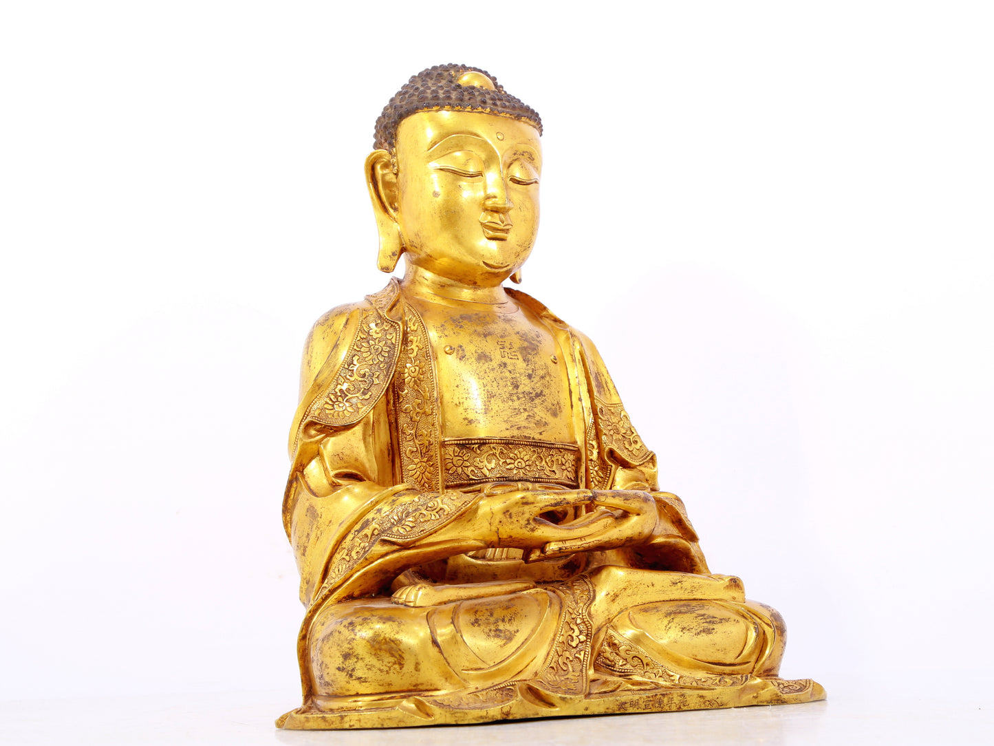 A serene gilt bronze statue of Gautama Buddha