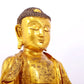 A serene gilt bronze statue of Gautama Buddha