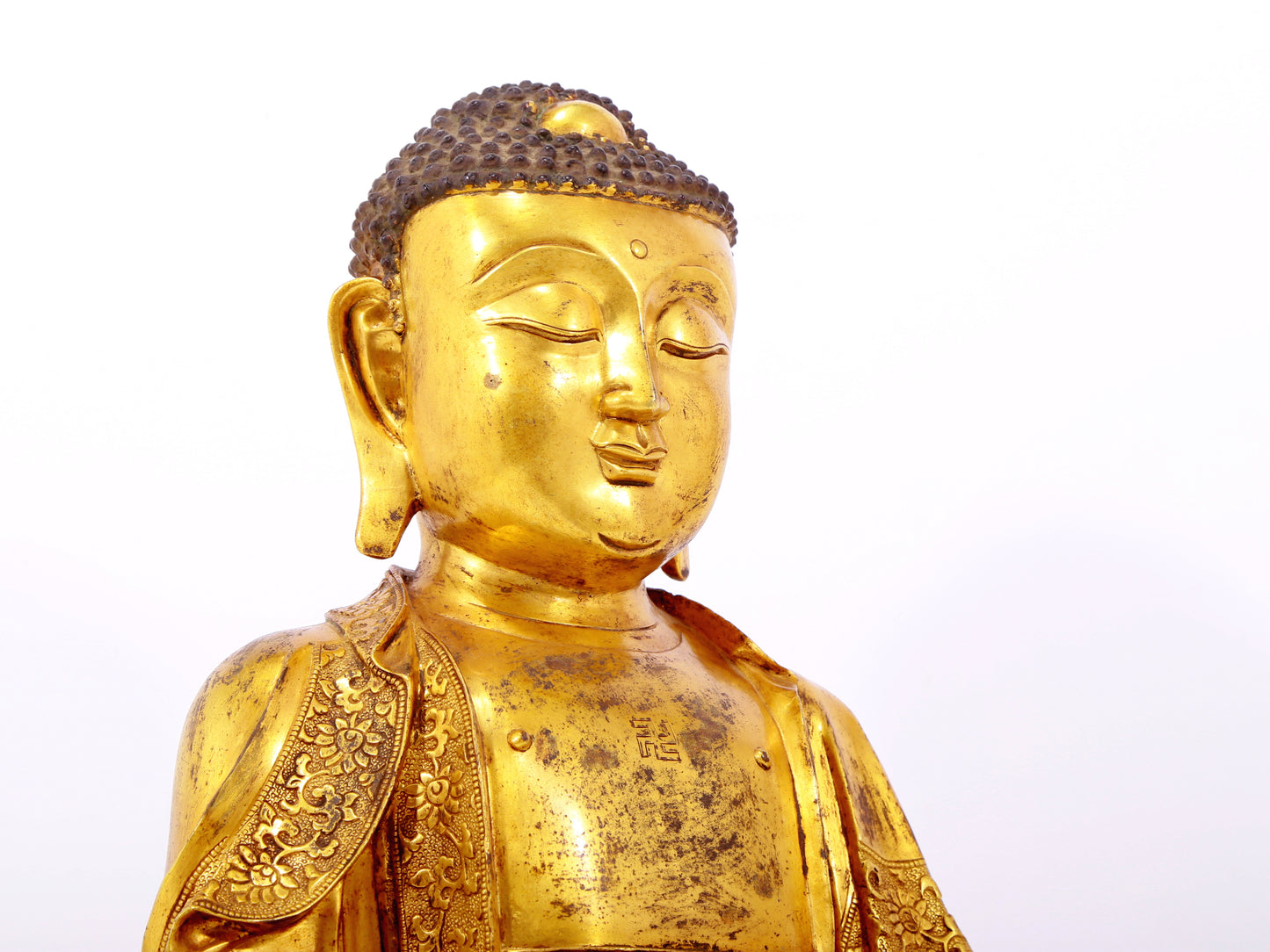 A serene gilt bronze statue of Gautama Buddha