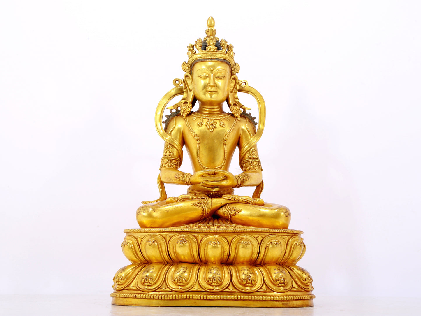 A serene gilt bronze statue of Amitayus Buddha