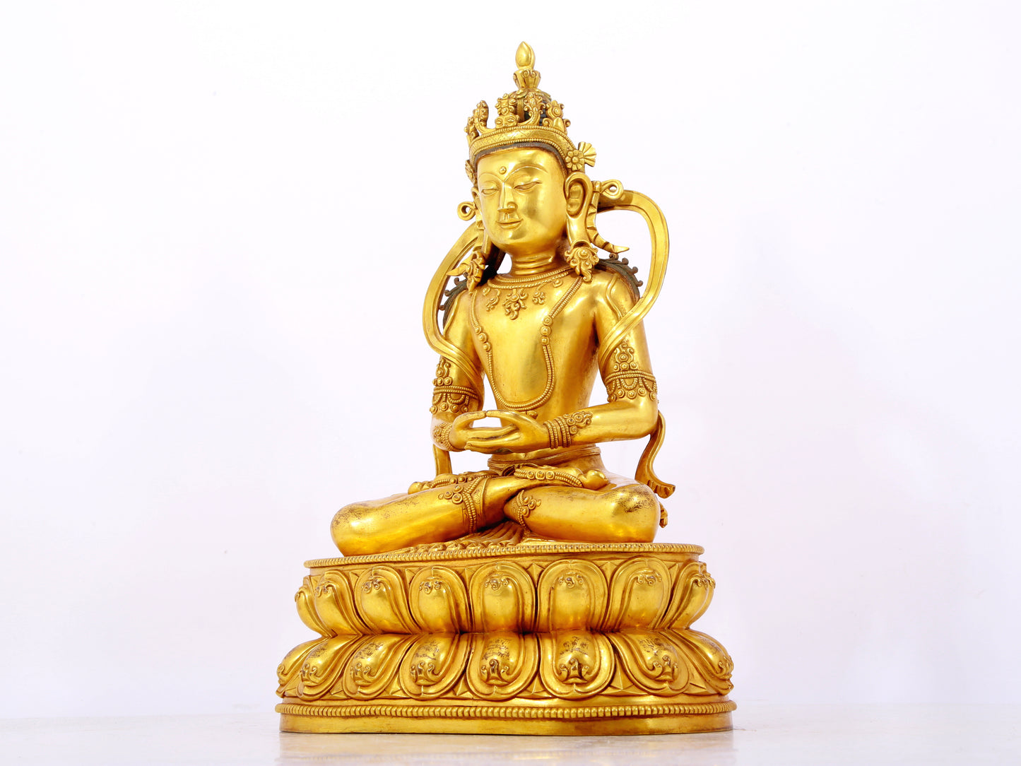 A serene gilt bronze statue of Amitayus Buddha