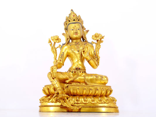 A serene gilt bronze statue of Tara inlaid with sapphire green