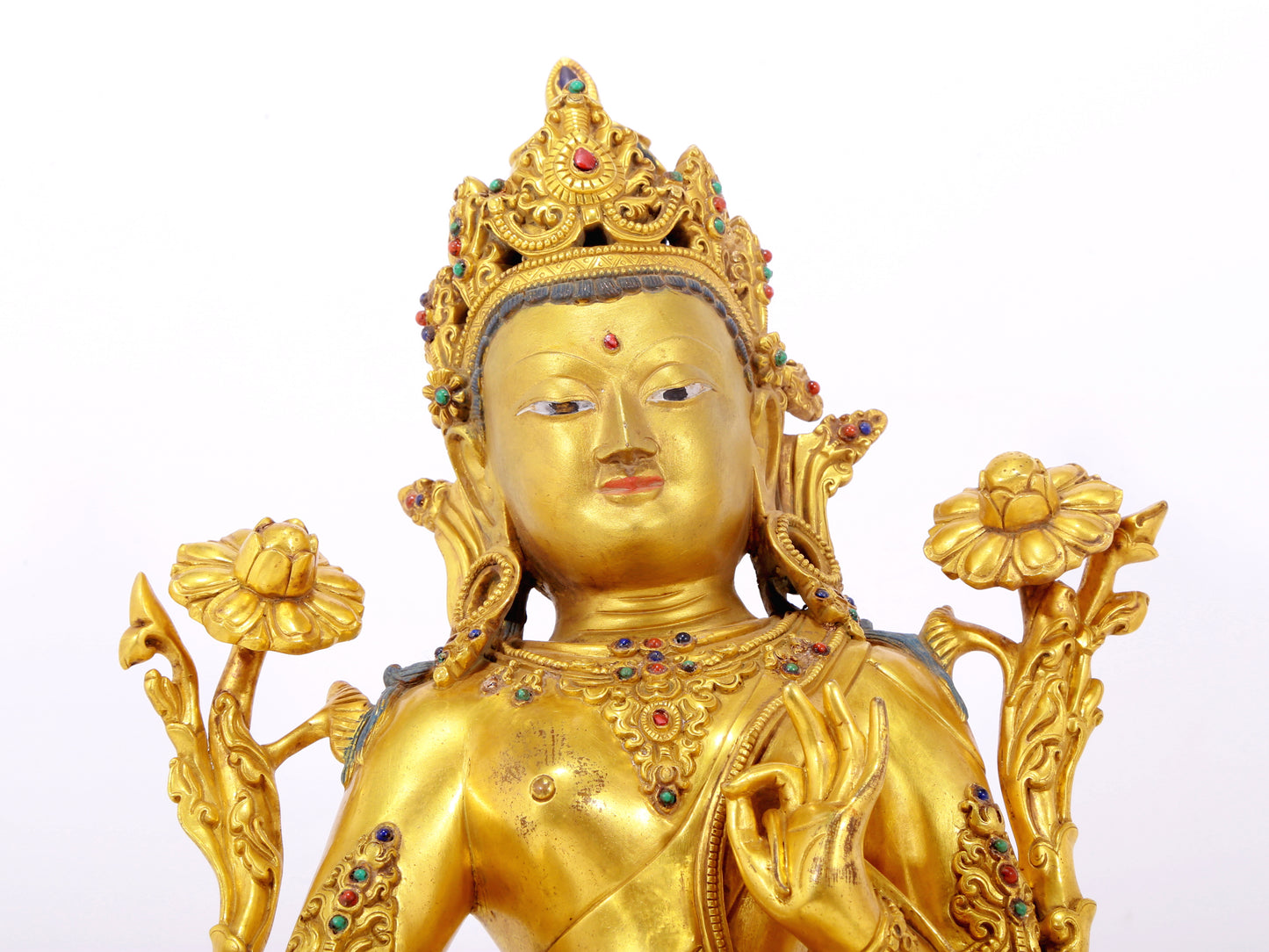 A serene gilt bronze statue of Tara inlaid with sapphire green