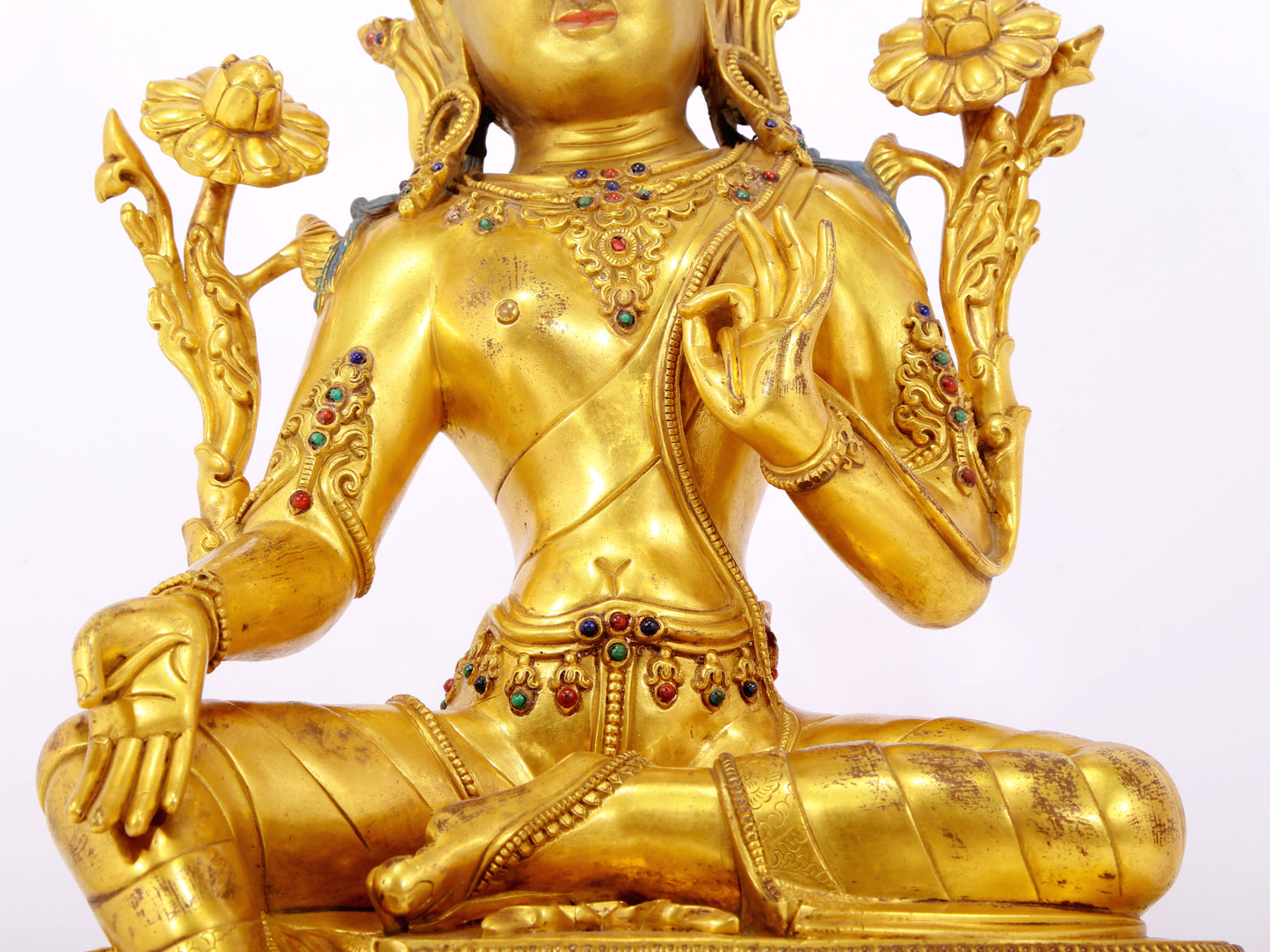 A serene gilt bronze statue of Tara inlaid with sapphire green