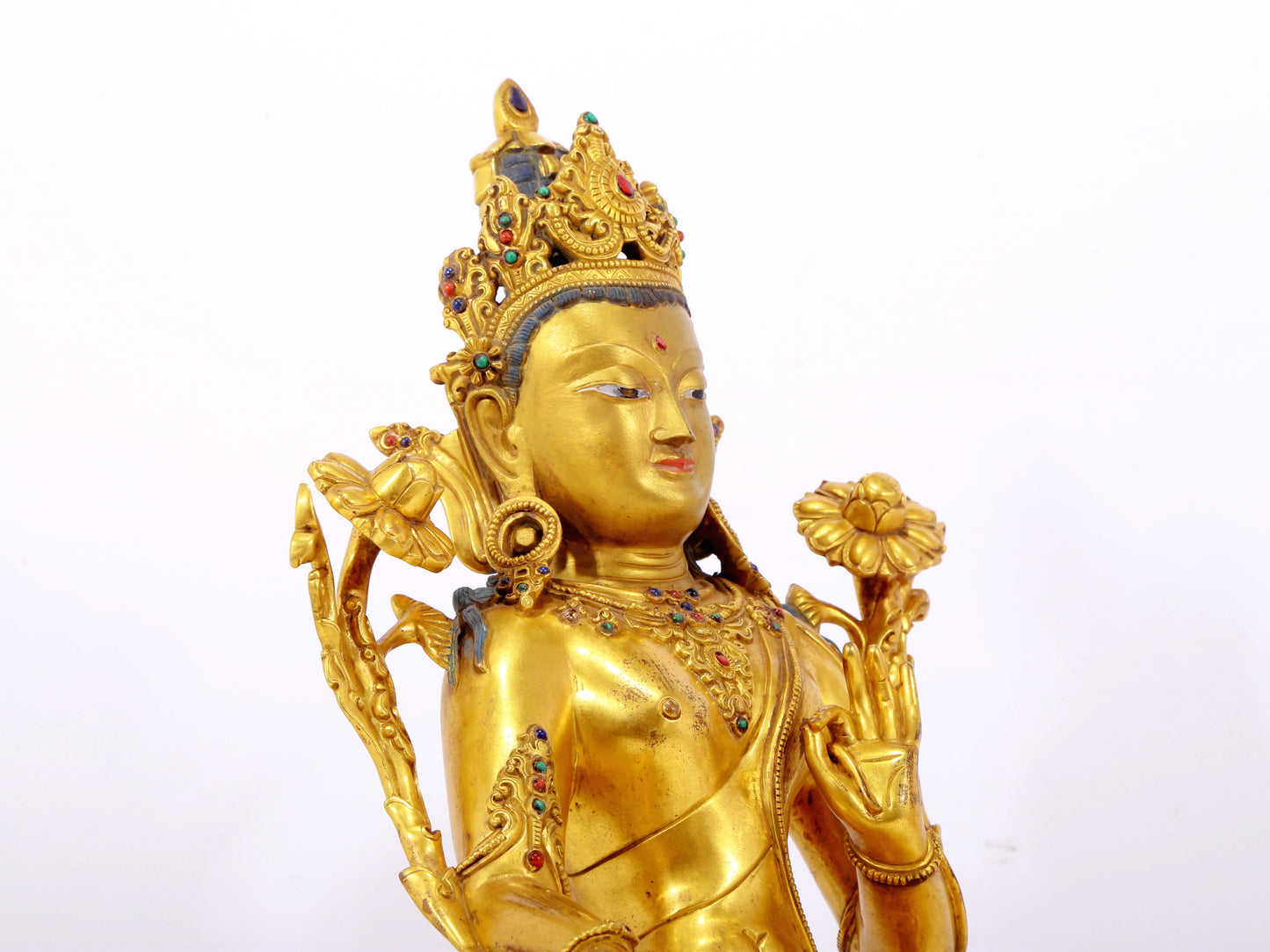 A serene gilt bronze statue of Tara inlaid with sapphire green