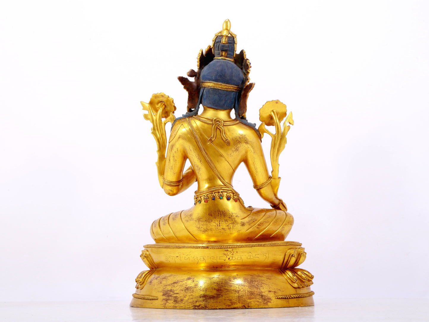 A serene gilt bronze statue of Tara inlaid with sapphire green