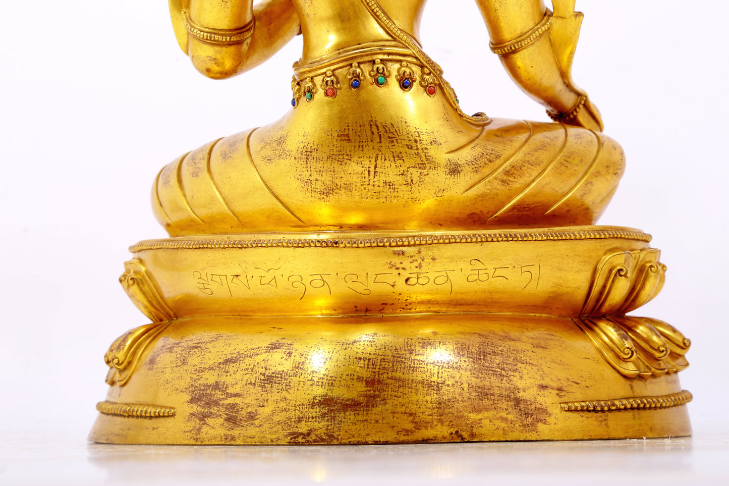 A serene gilt bronze statue of Tara inlaid with sapphire green