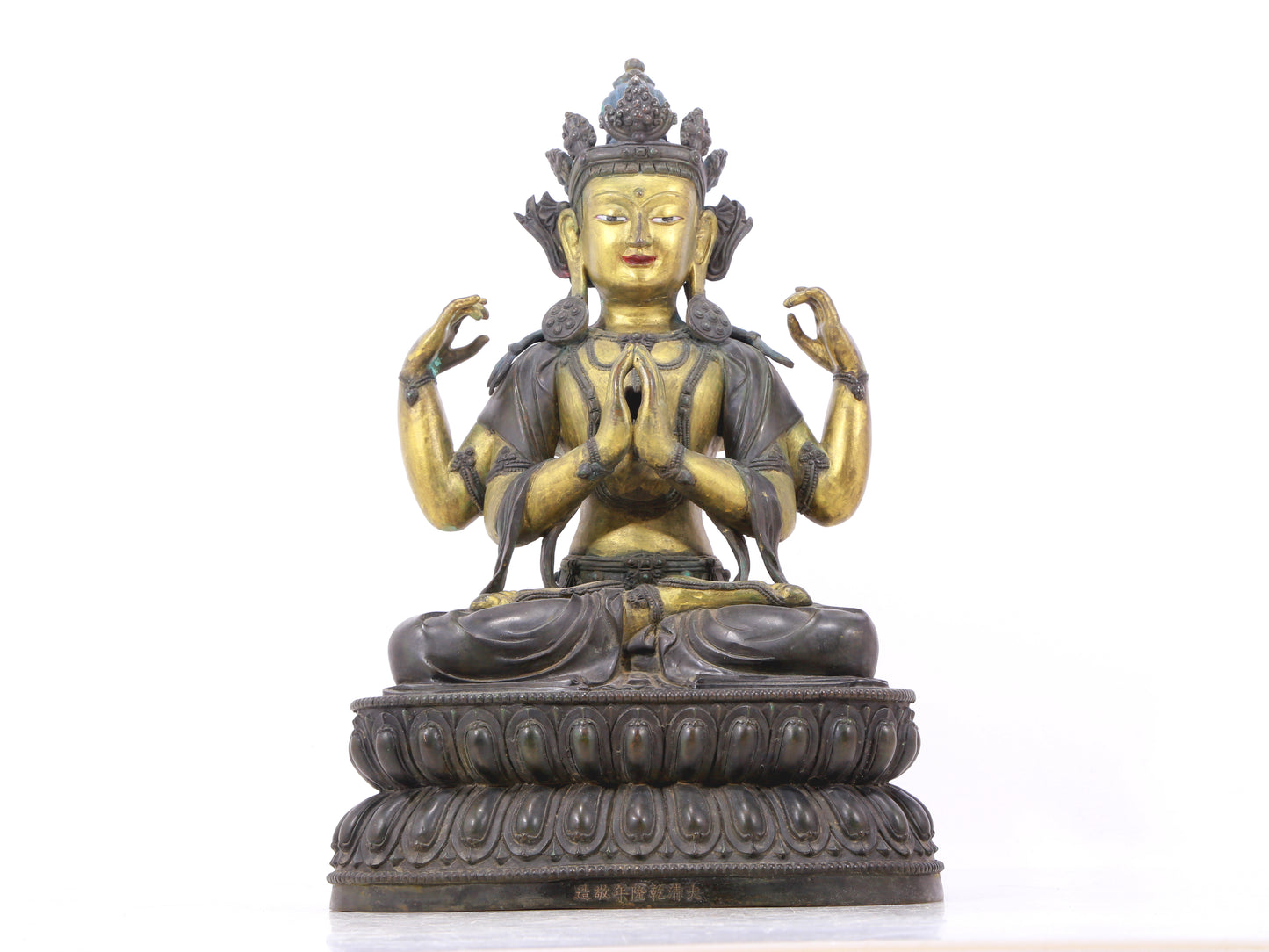 A serene gilt bronze four-armed Guanyin statue