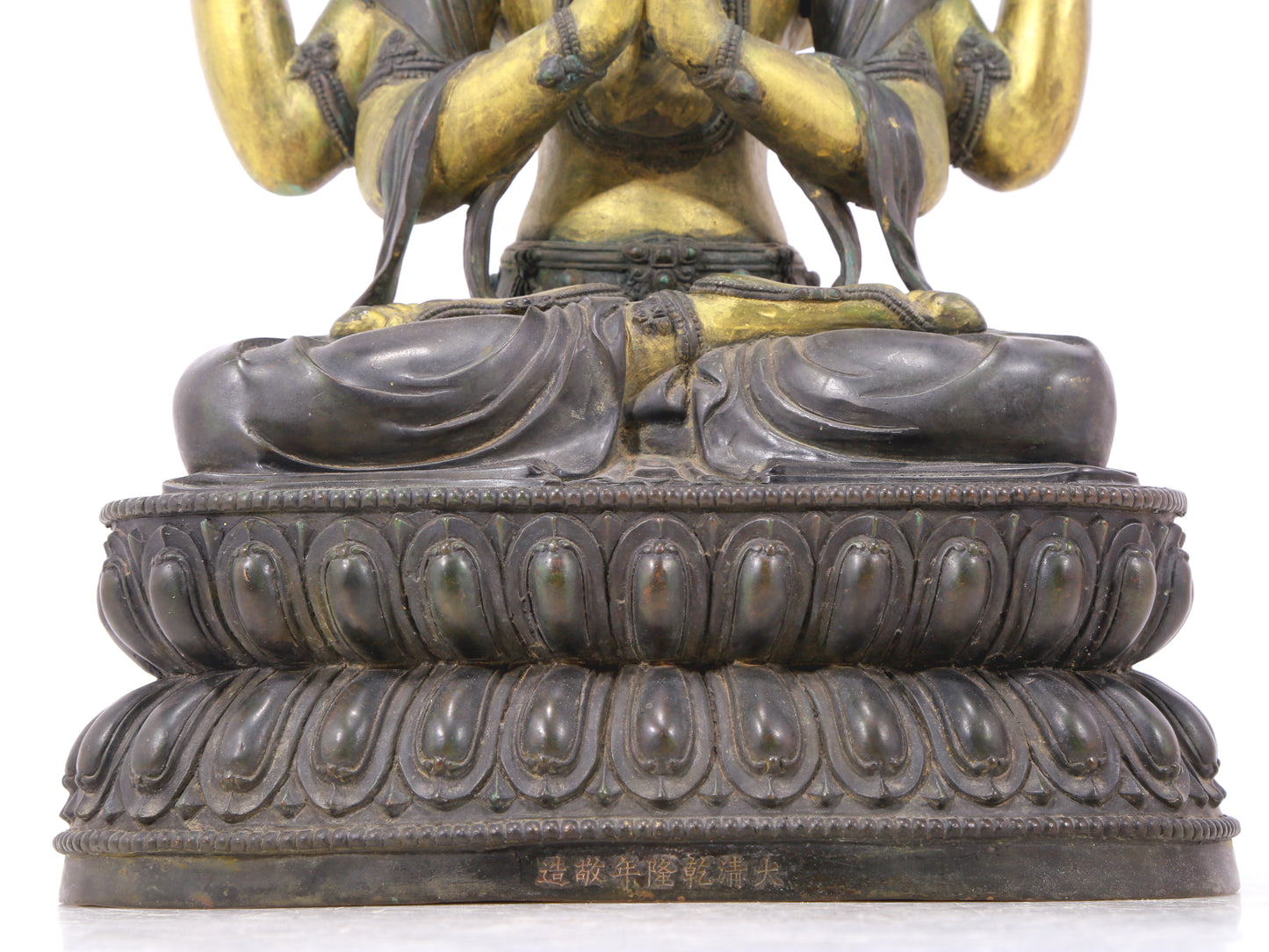 A serene gilt bronze four-armed Guanyin statue