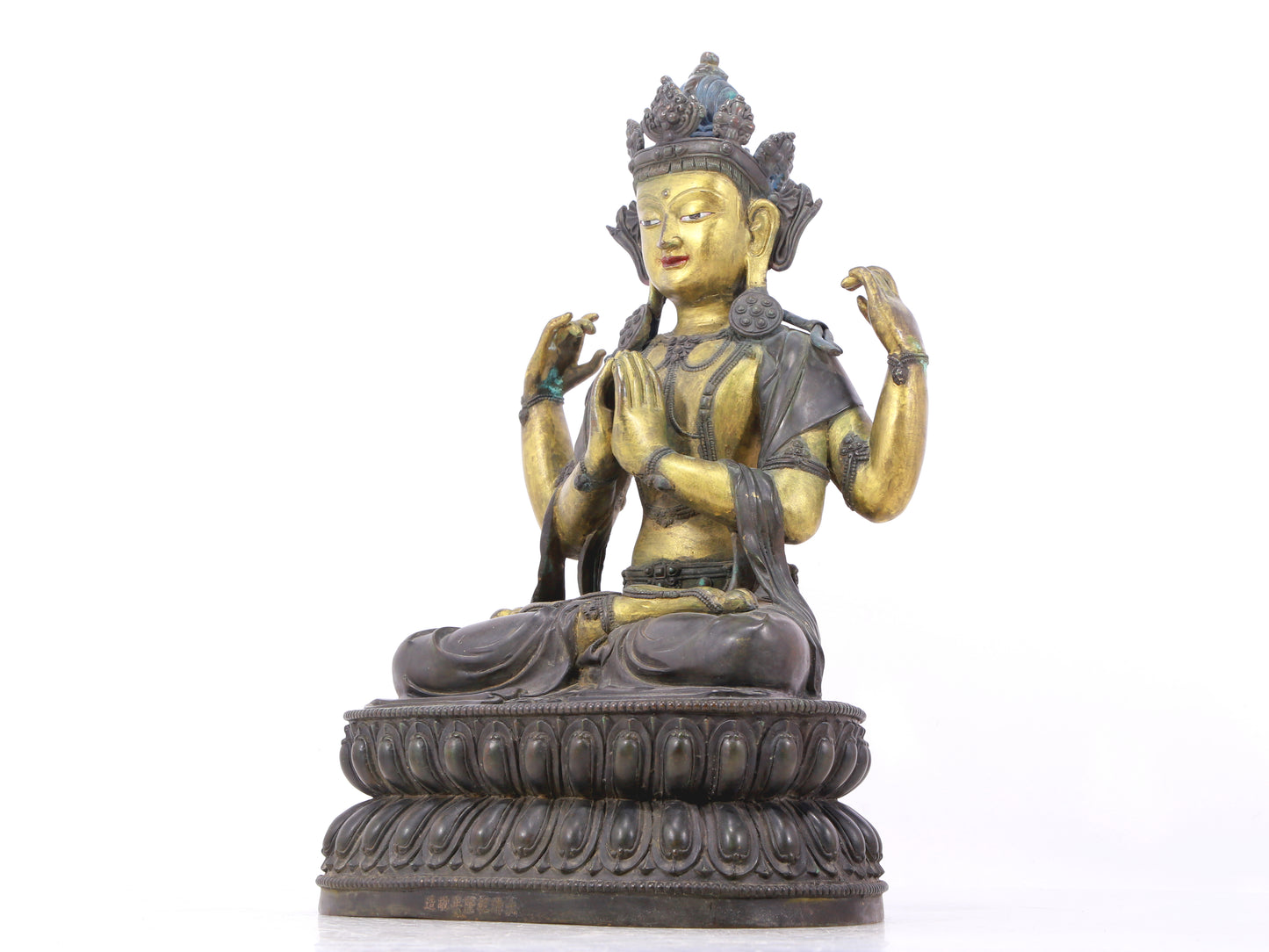 A serene gilt bronze four-armed Guanyin statue