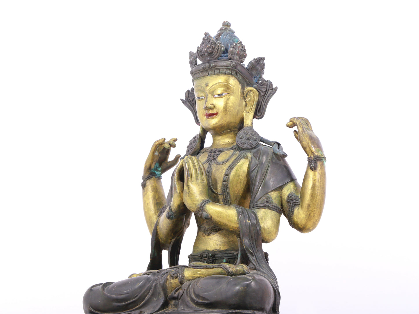 A serene gilt bronze four-armed Guanyin statue