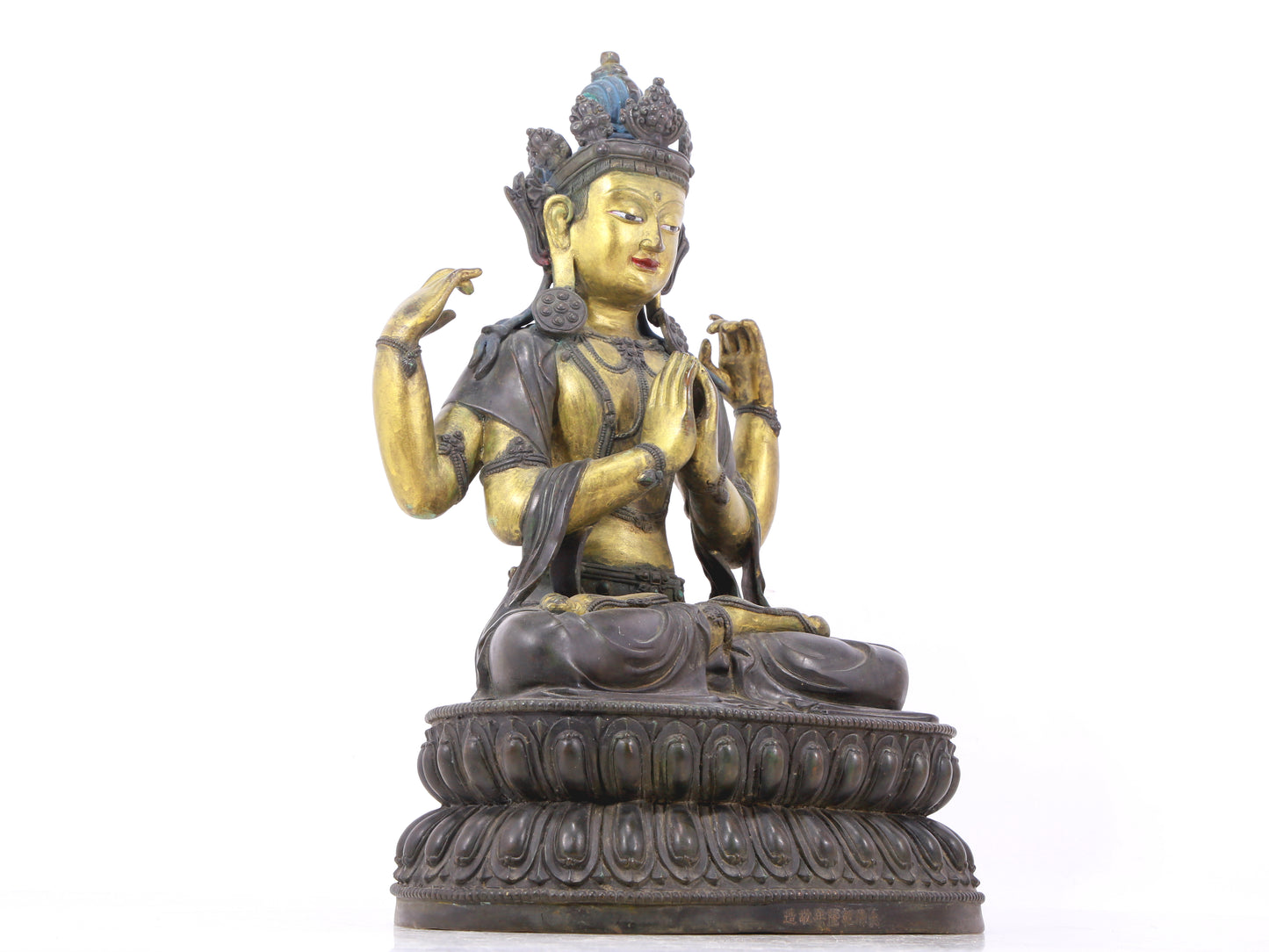 A serene gilt bronze four-armed Guanyin statue